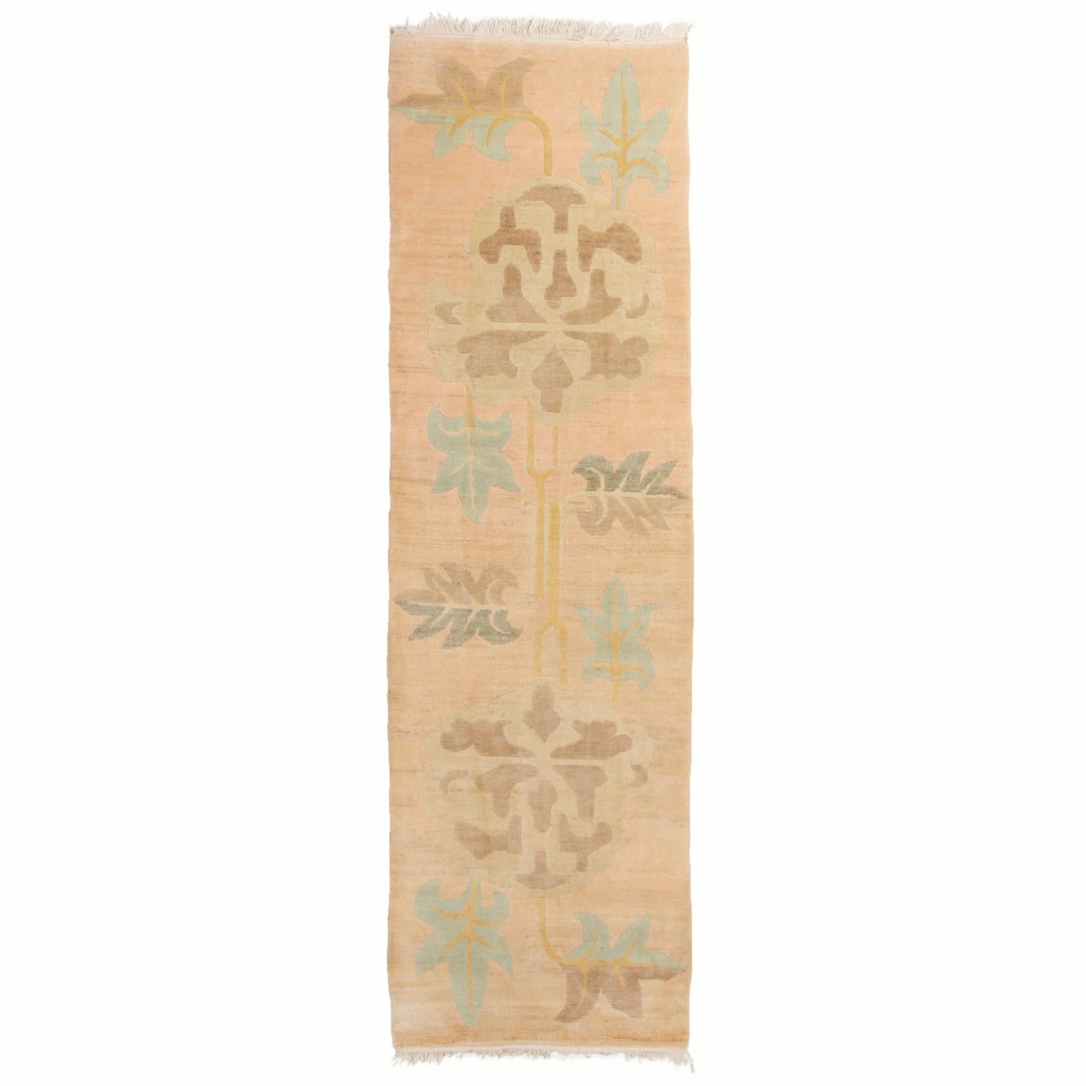 Hand knotted in Nepal with high quality wool, this borderless Beama design runner sports an abrash tan-beige background, hosting a unique pastel array of island blue, purple, and golden flower motifs in the sharply drawn all-over field design.
   