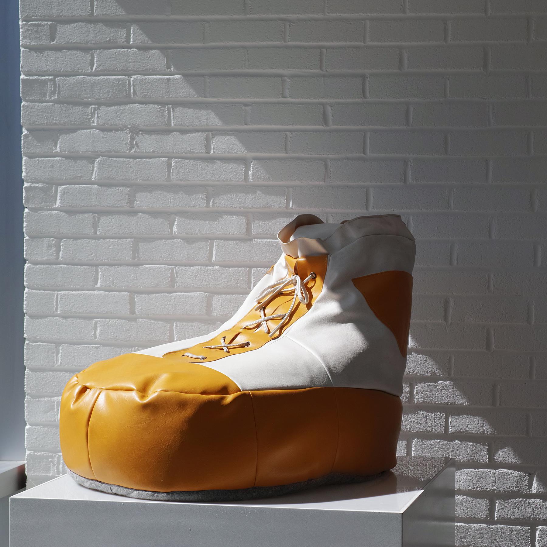 Per la tua considerazione c'è questa sedia a sacco a forma di scarpa grande rivestita in vinile bianco e giallo attribuita a DeSede. Questa scarpa grande può essere utilizzata come pouf o poggiapiedi e presenta due tasche laterali e un laccio sul