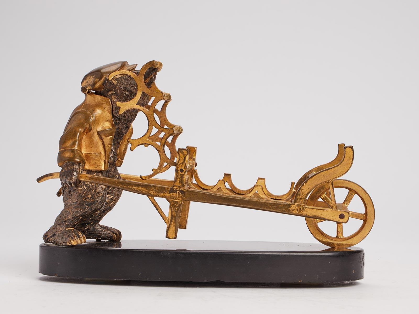 Inkwell and fountain pens holder, silver and gold gilt bronze sculpture of a dressed bear, pushing a wheelbarrow, over a Belgian black marble base. Cabochon garnet eyes, Russia, 1880 ca.