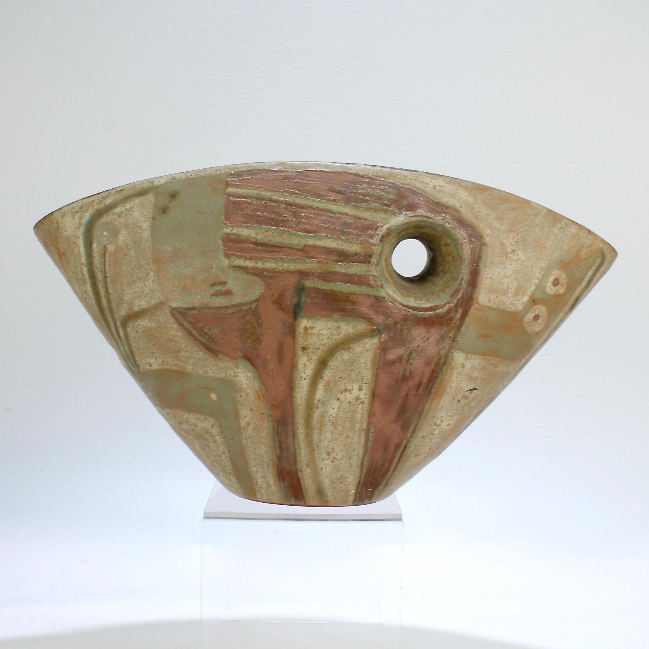 A fine and rare Beate Kuhn vessel.

With a fan shaped body, abstract polychrome decoration to both sides, and a typical cylindrical opening through the center. 

The foot bears a Beate Kuhn spiral studio mark, an old Beate Kuhn Düdelsheim Kreis