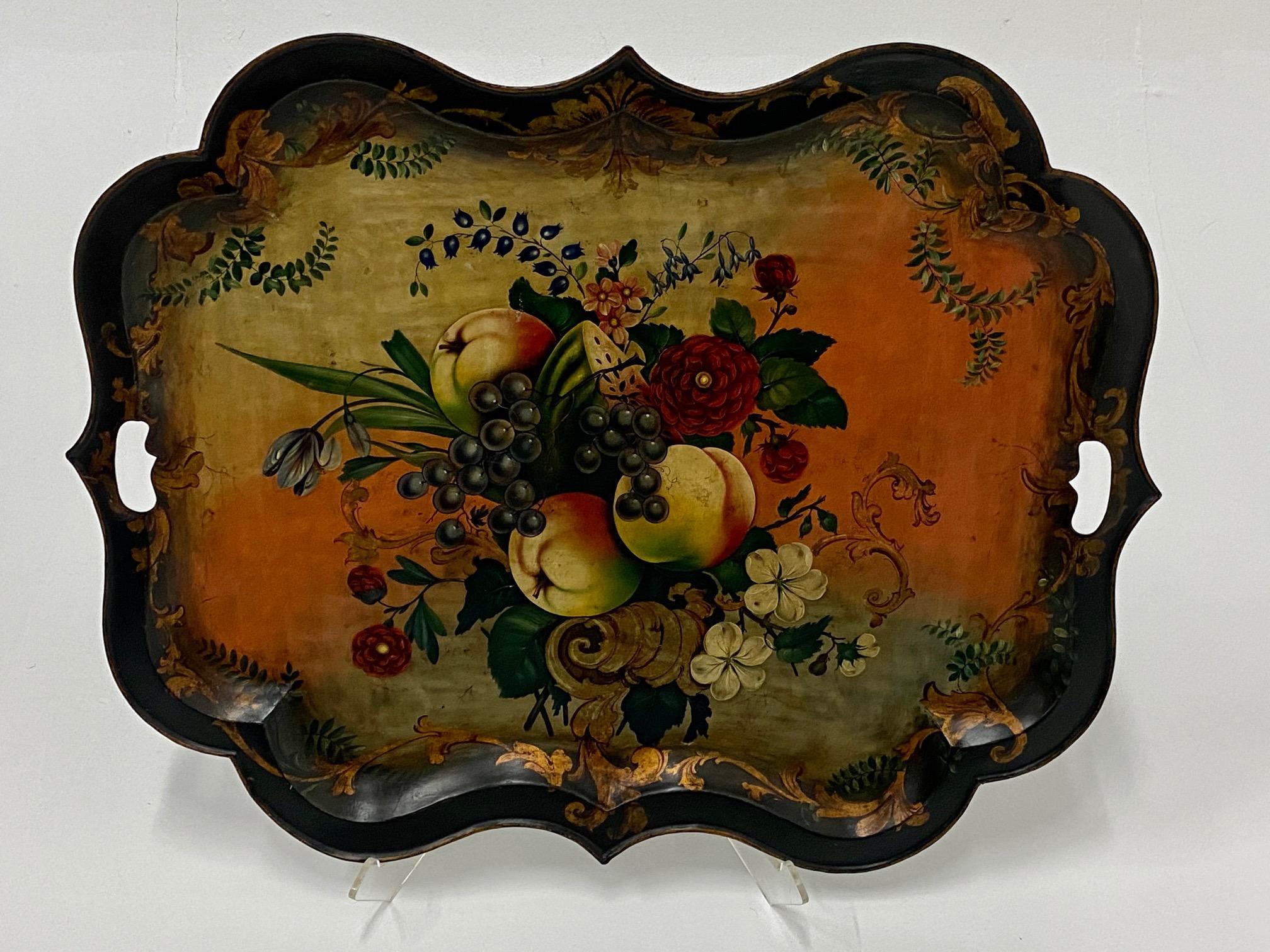 A large and gorgeously decorated antique metal tole tray having scalloped edges and lavishly painted fruit and flowers. Signed illegibly on back.