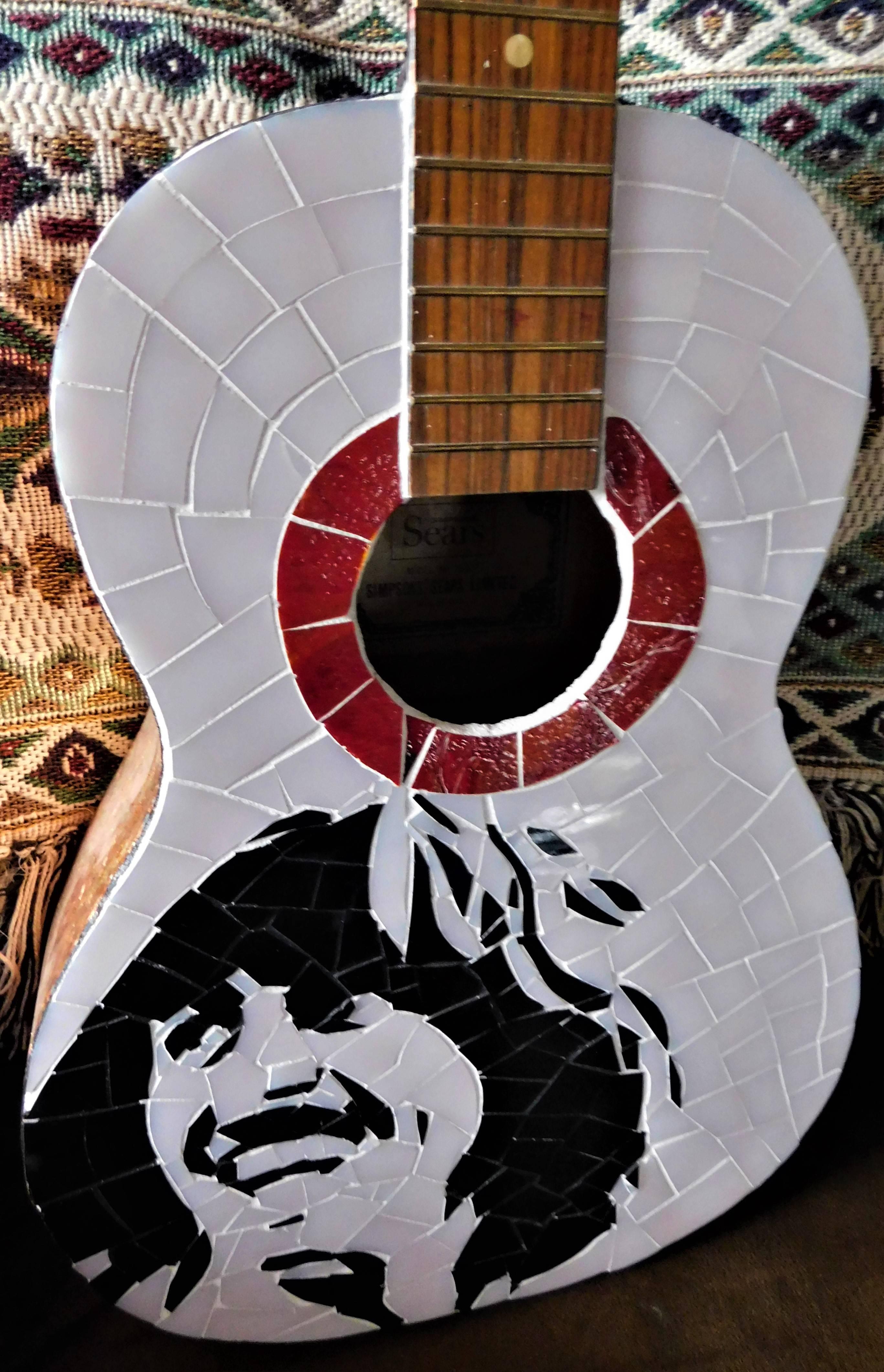 This George Harrison stained glass acoustic guitar was created by Brantford, Ontario, Canada artist Lily Crawford in 2012 and signed on the back. The sides are covered with gold leaf. The guitar was made for Simpson Sears, made in Japan. The image