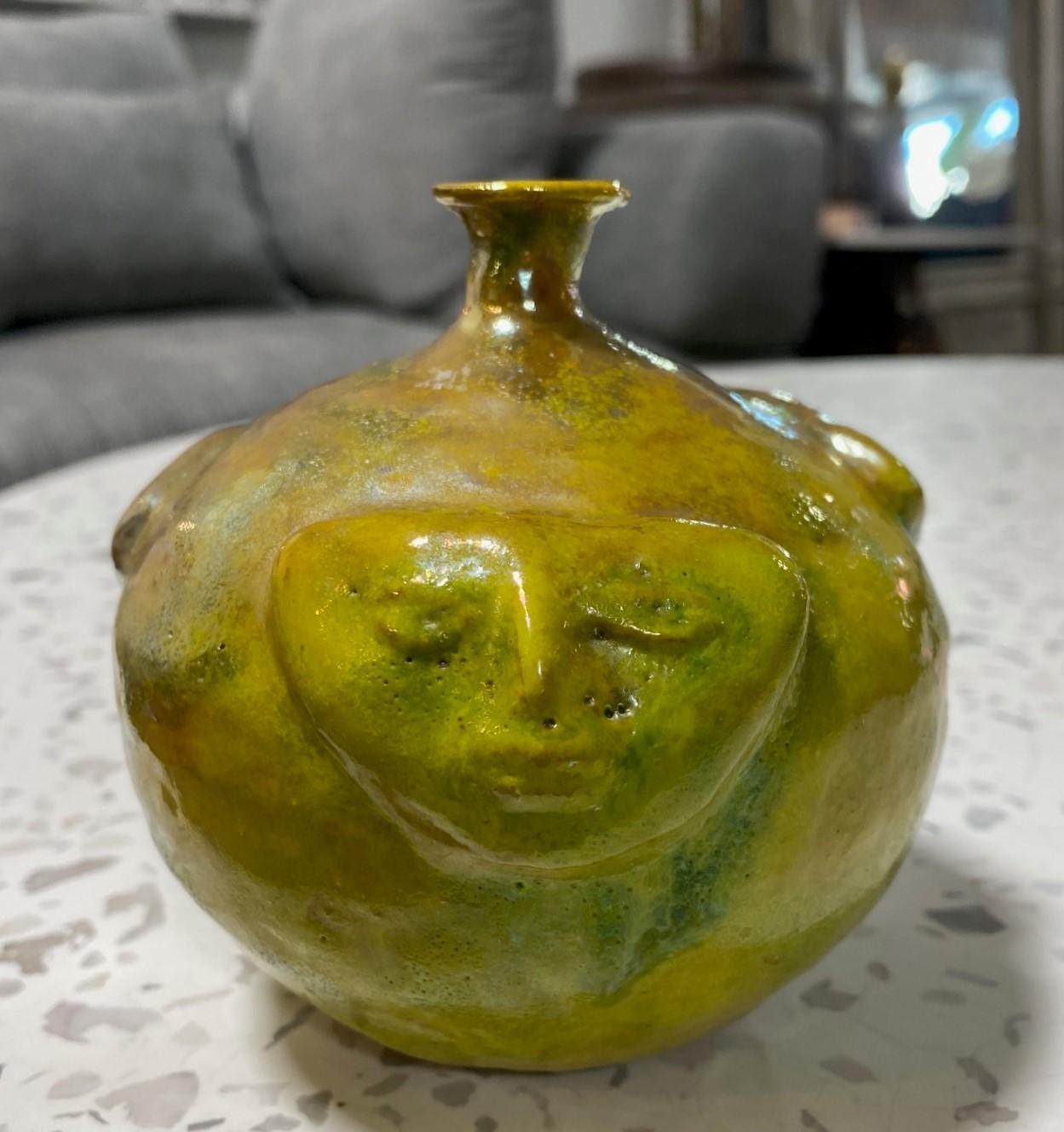 A wonderful gem of a piece by famed American/California ceramicist Beatrice Wood featuring her highly coveted iridescent luster glaze and highly desired face design. The gorgeous and sumptuous glaze radiants various shades and colors (greens,
