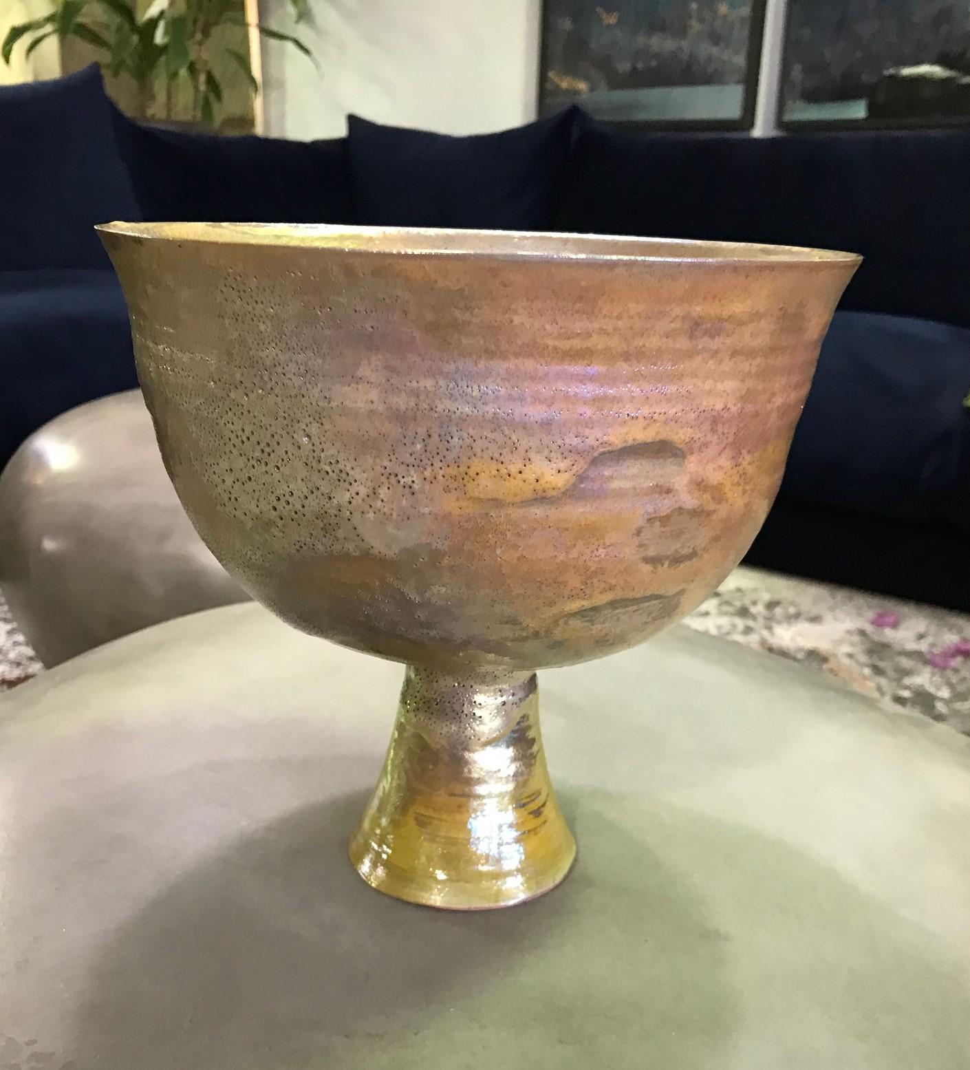 A wonderful piece by famed American ceramist Beatrice Wood featuring her highly coveted Iridescent luster glaze. A wonderful design rising on a circular base with a rich golden glaze that shimmers in the light sumptuously applied by Beatrice.