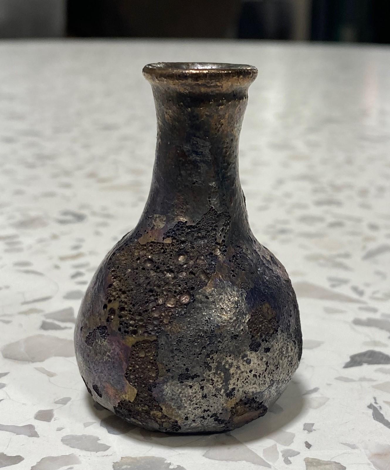 Una obra maravillosamente diseñada por la famosa maestra ceramista Beatrice Wood, del American California Studio, con un precioso esmalte metálico iridiscente oscuro de cráter de lava volcánica (lustre).  Una forma clásica e intemporal, el esmalte