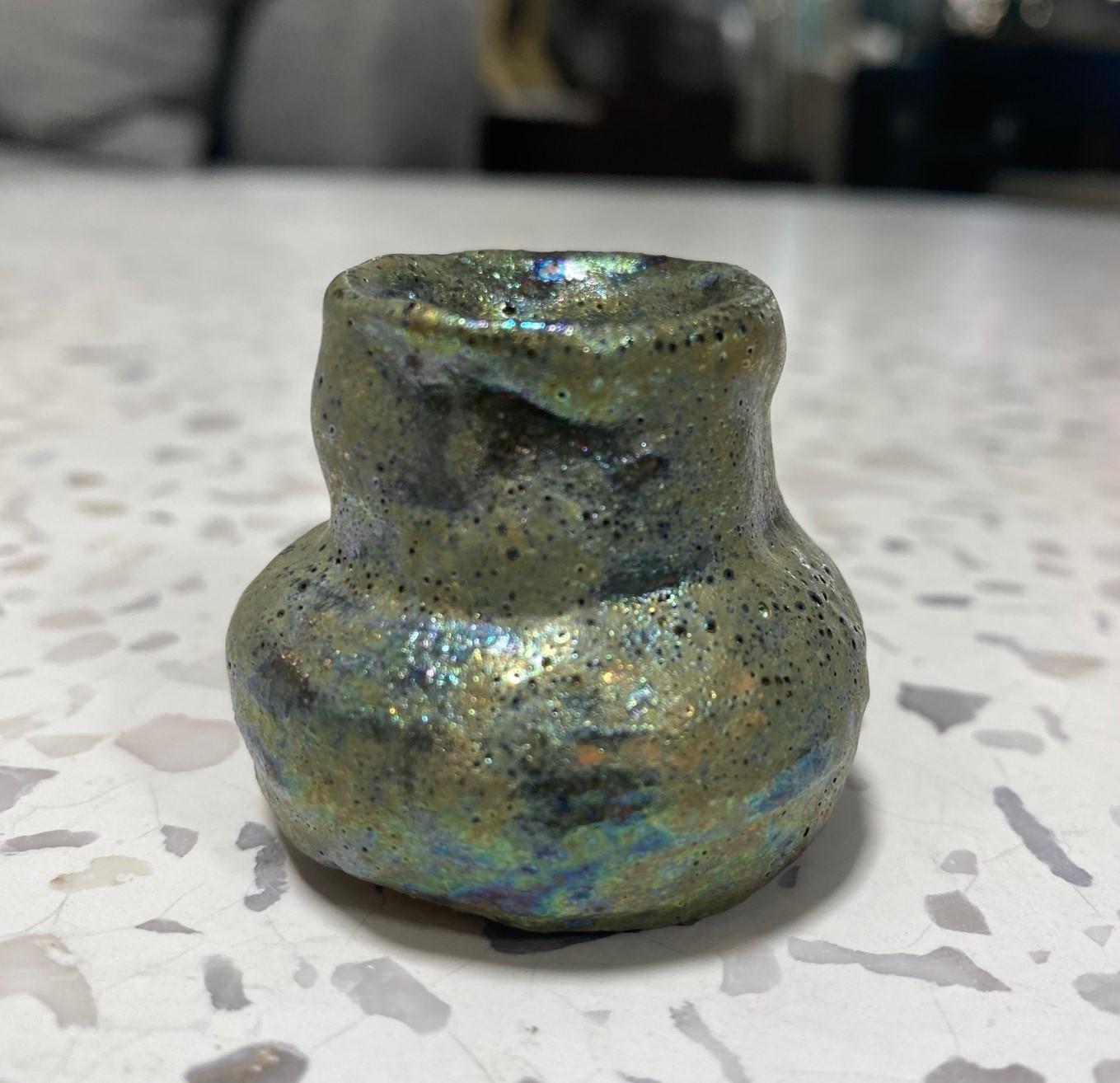 Maravillosa joya absoluta de la famosa ceramista californiana Beatrice Wood, con su codiciado esmalte iridiscente de lava volcánica (cráter).  Es muy posible que este jarrón/recipiente/macetero en miniatura sea la pieza más pequeña que haya