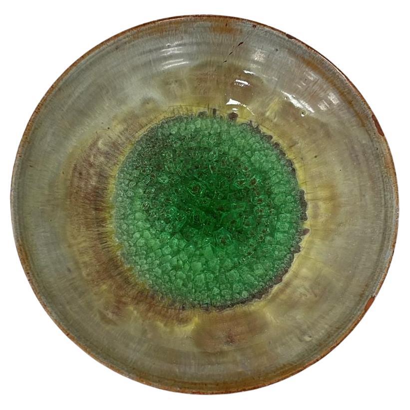 A gorgeous and very uncommon early lava glazed bowl with a bright lime crystallize center by famed American ceramist Beatrice Wood. This piece radiates under the light. Signed by Wood on the underside. This was right around the time when she changed