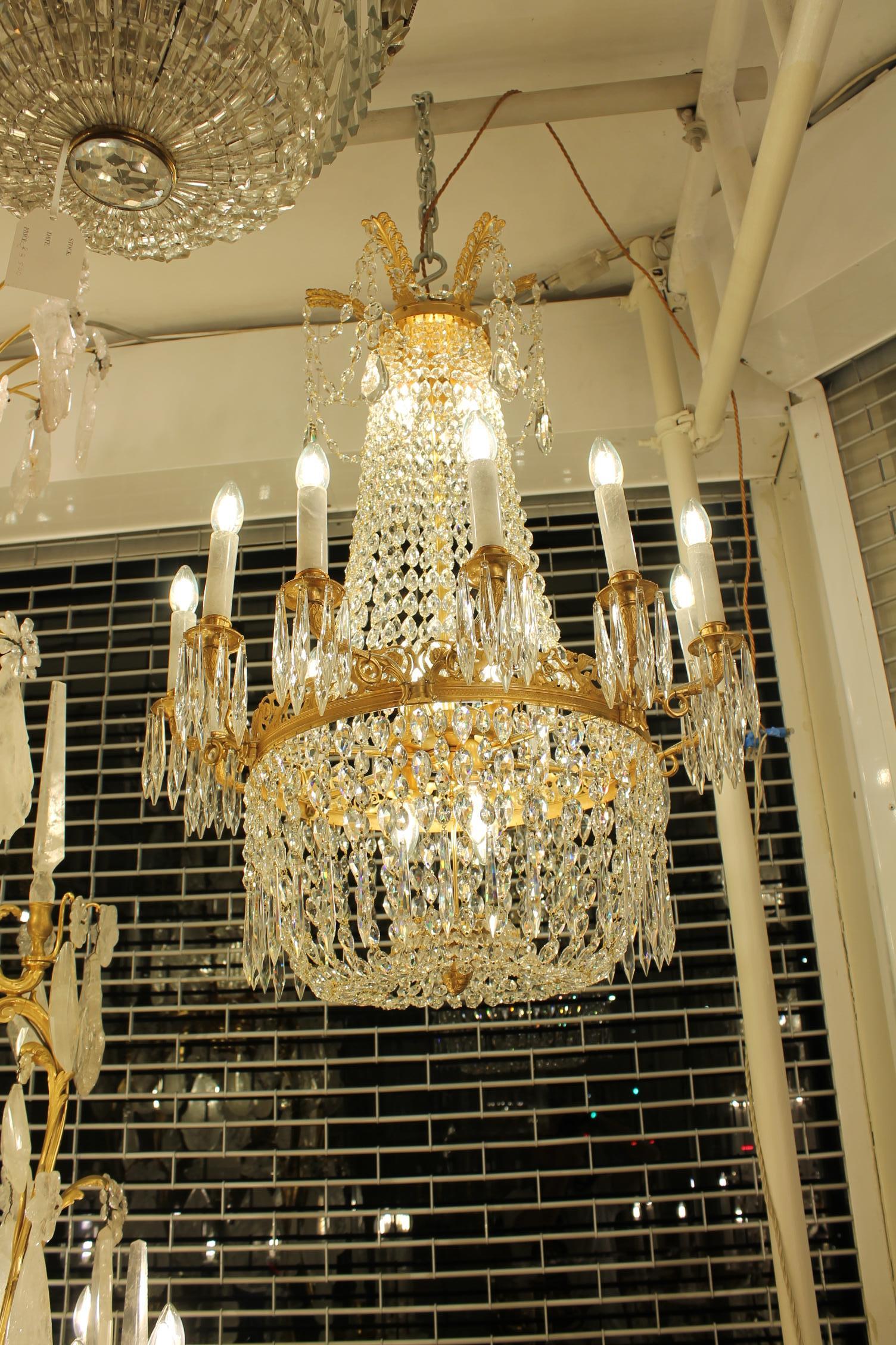 Un bellissimo lampadario a cesto a 12 bracci e 21 luci di origine francese.
12 braccia che emanano da una cintura centrale dorata da cui si diramano le braccia. Ogni braccio è dotato di una leccarda in ottone da cui scendono ghiaccioli di cristallo.