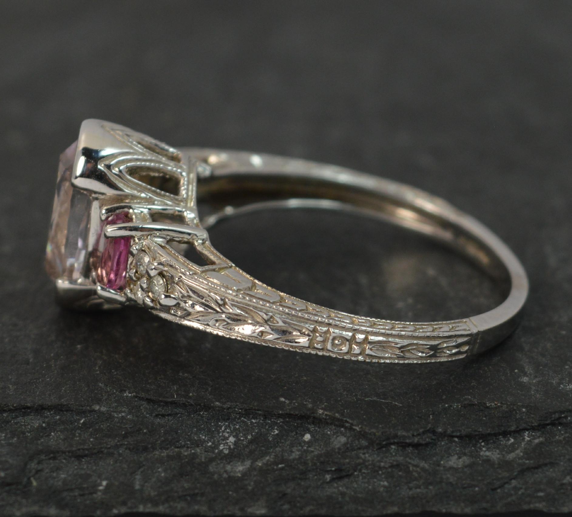 A superb 14 carat white gold, kunzite, pink tourmaline and diamond ring.
Size ; T UK, 9 1/2 US
Designed with oval cut gemstones to the centre to form a 12mm x 12mm trilogy and three small diamonds to each side.

Solid 14ct white gold example with