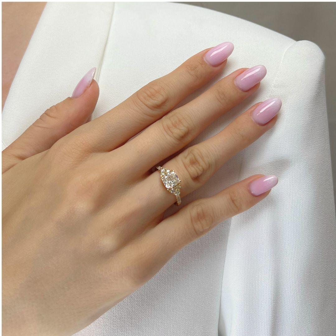Indulge in the refined beauty of this 18k yellow gold diamond pavé ring, featuring a captivating 1.51-carat cushion-cut center diamond. While 12 round side diamonds totaling 0.31-carat create a dazzling pavé setting that perfectly complements the