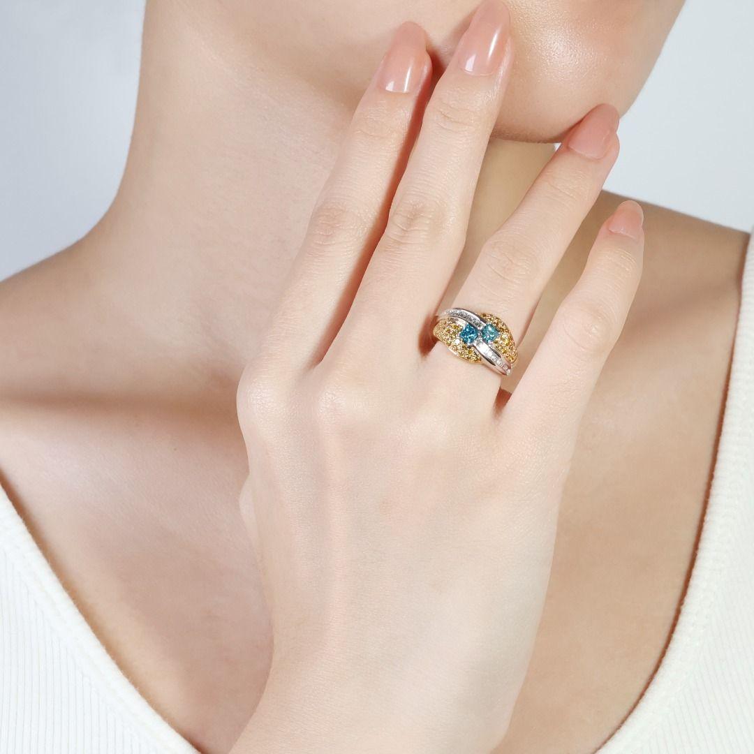 Presenting a truly unique and captivating 18k two-tone gold ring, designed to make a statement. This exquisite piece features a mesmerizing duo of princess-cut blue diamonds totaling an impressive 0.55-carat weight. Flanking these centerpieces are