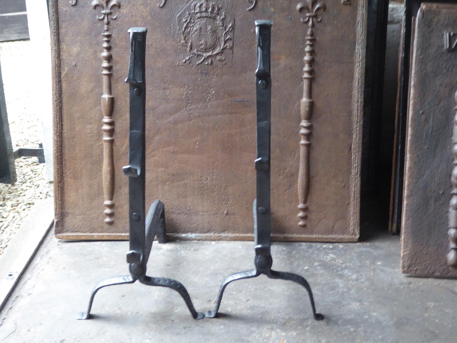 Beautiful 17th-18th century French andirons made of wrought iron. The style of the andirons is Louis XIII. They have black patina. The andirons have spit hooks to grill food. They are in a good condition, despite their age.







 