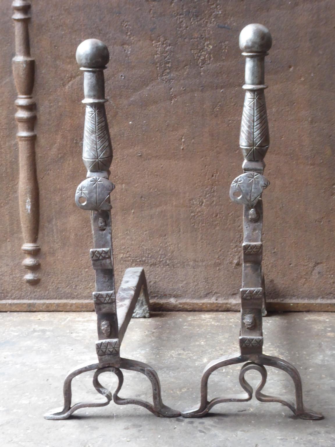 Beautiful 17th century French andirons made of wrought iron. The style of the andirons is Louis XIII and they are from that period. They have a natural brown patina. The andirons have spit hooks to grill food. They are in a good condition, despite