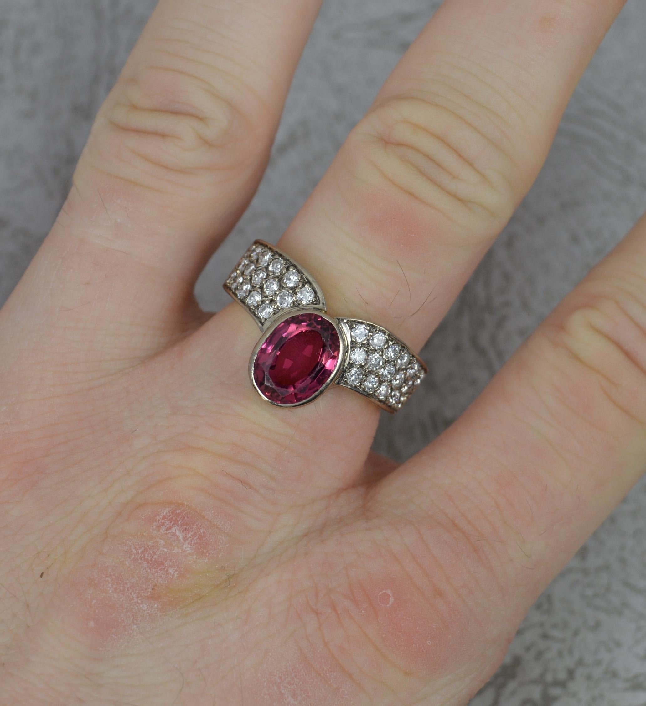 A superb Tourmaline and Diamond ring.
Solid 18 carat gold example.
An oval cut pink tourmaline to centre in full bezel setting. 7mm x 9mm.
16 natural round brilliant cut diamonds to each side. Very clean, bright and sparkle.

CONDITION ; Very good.
