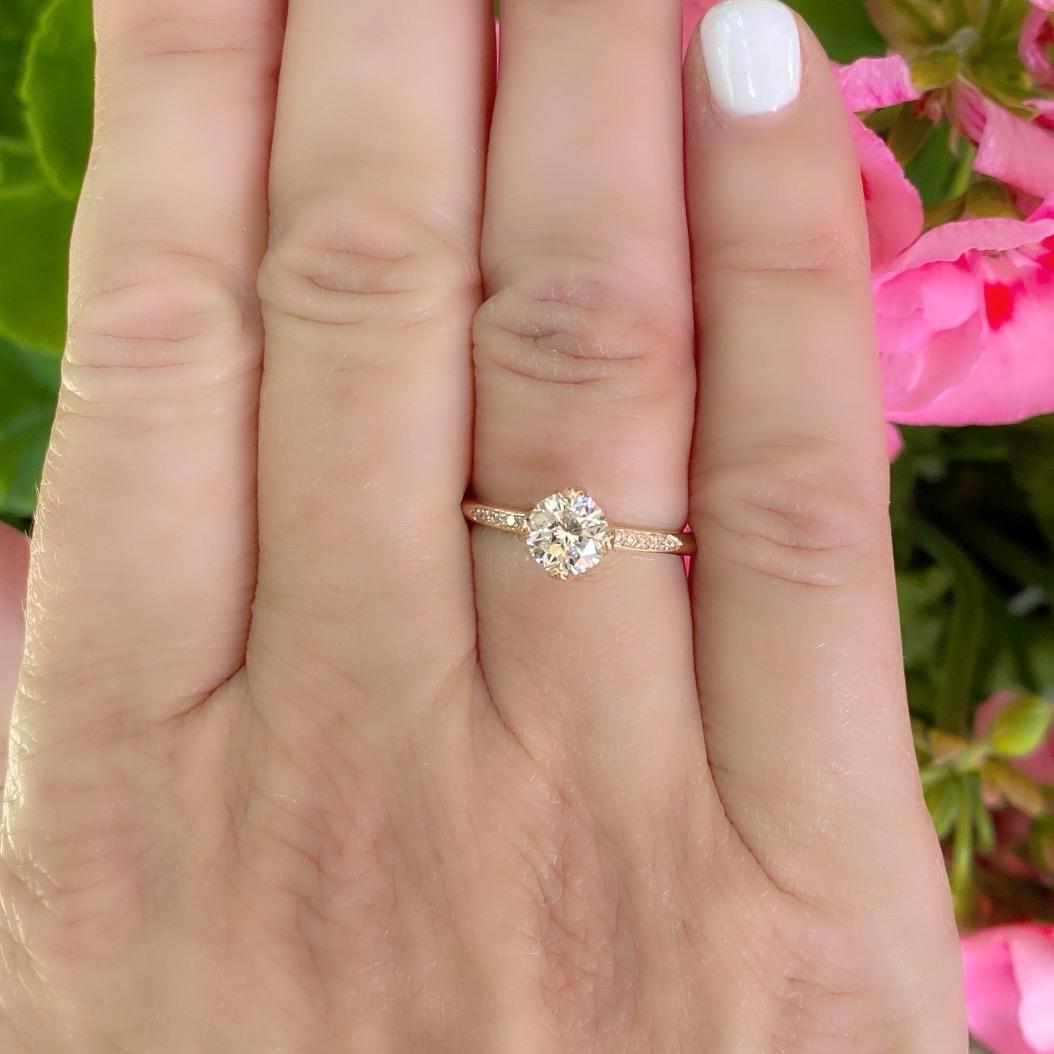 This 18 karat rose gold beauty features a round brilliant cut diamond weighing 1.01 carats that delivers tons of sparkle and fire! The center stone (graded as K/SI2) is perfectly set with four prongs with five diamonds intricately set in either side
