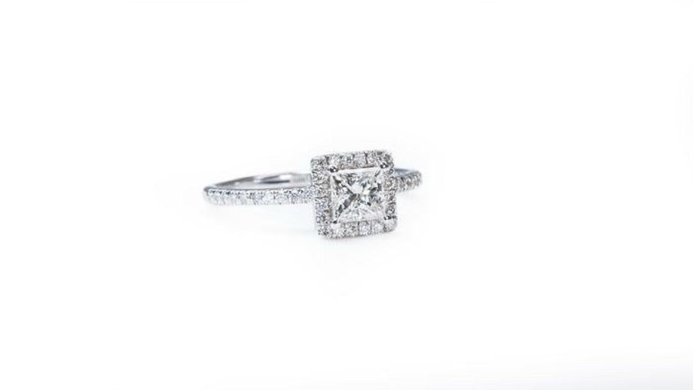 A beautiful halo solitaire ring with a dazzling 0.90 carat princess cut natural diamond in D VVS1, the whitest and highest possible colour grade of a diamond. This ring has 0.12 carat of side stone diamonds which adds more to its elegance. The