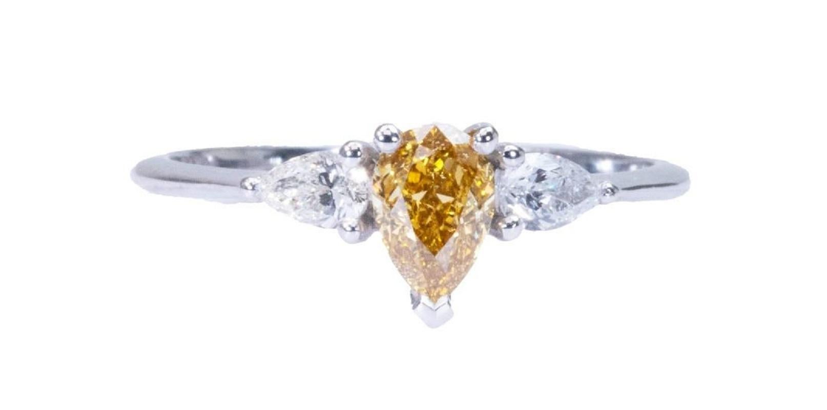 Stunning and one of a kind 3 stone ring made from 18k white gold with 0.77 total carat of natural pear shape diamond with amazing brownish yellow color with 2 pear shape diamonds on the side. This ring comes with an AIG certificate and a fancy