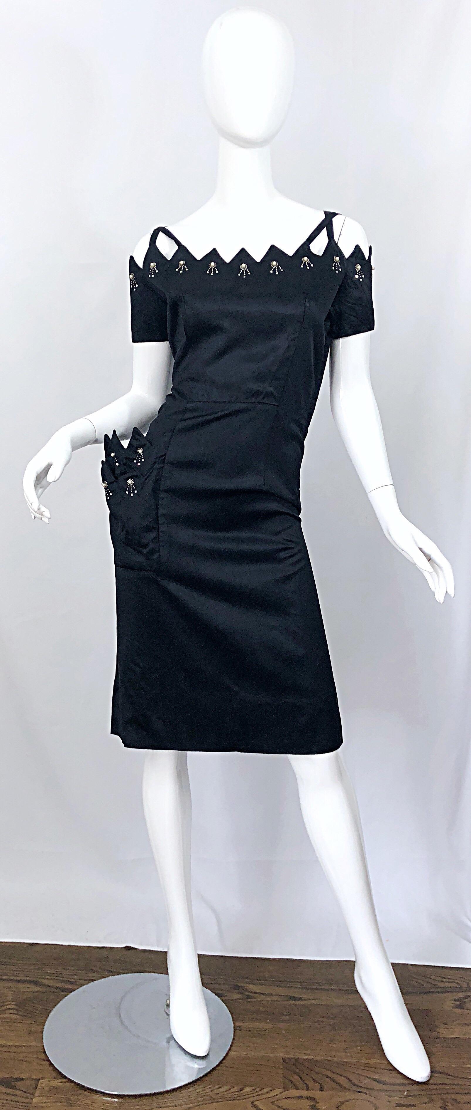 Beautiful 50s demi couture black rhinestone and bead encrusted cut-out scallop neck silk dress! Features an amazing scalloped neckline with cut-out criss cross shoulder straps. Rhinestones and beads hand-sewn along the neck and sleeves. Hidden metal