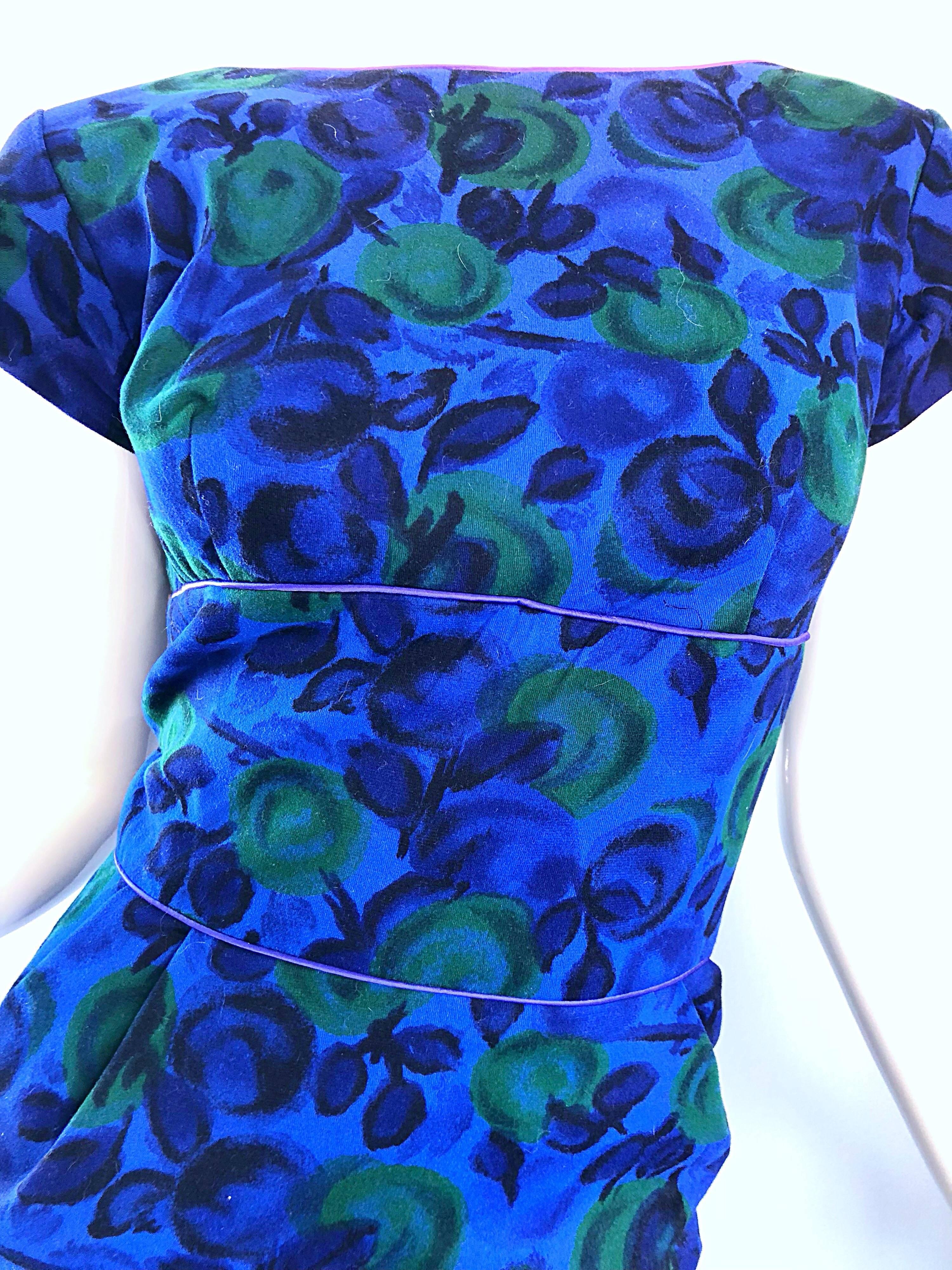 Magnifique robe en laine imprimée de fruits bleu royal et vert des années 1950 ! Fabuleuse coupe flatteuse qui s'étire pour épouser la forme du corps. Manches courtes à capuchon. Fermeture à glissière en métal sur toute la longueur du dos avec