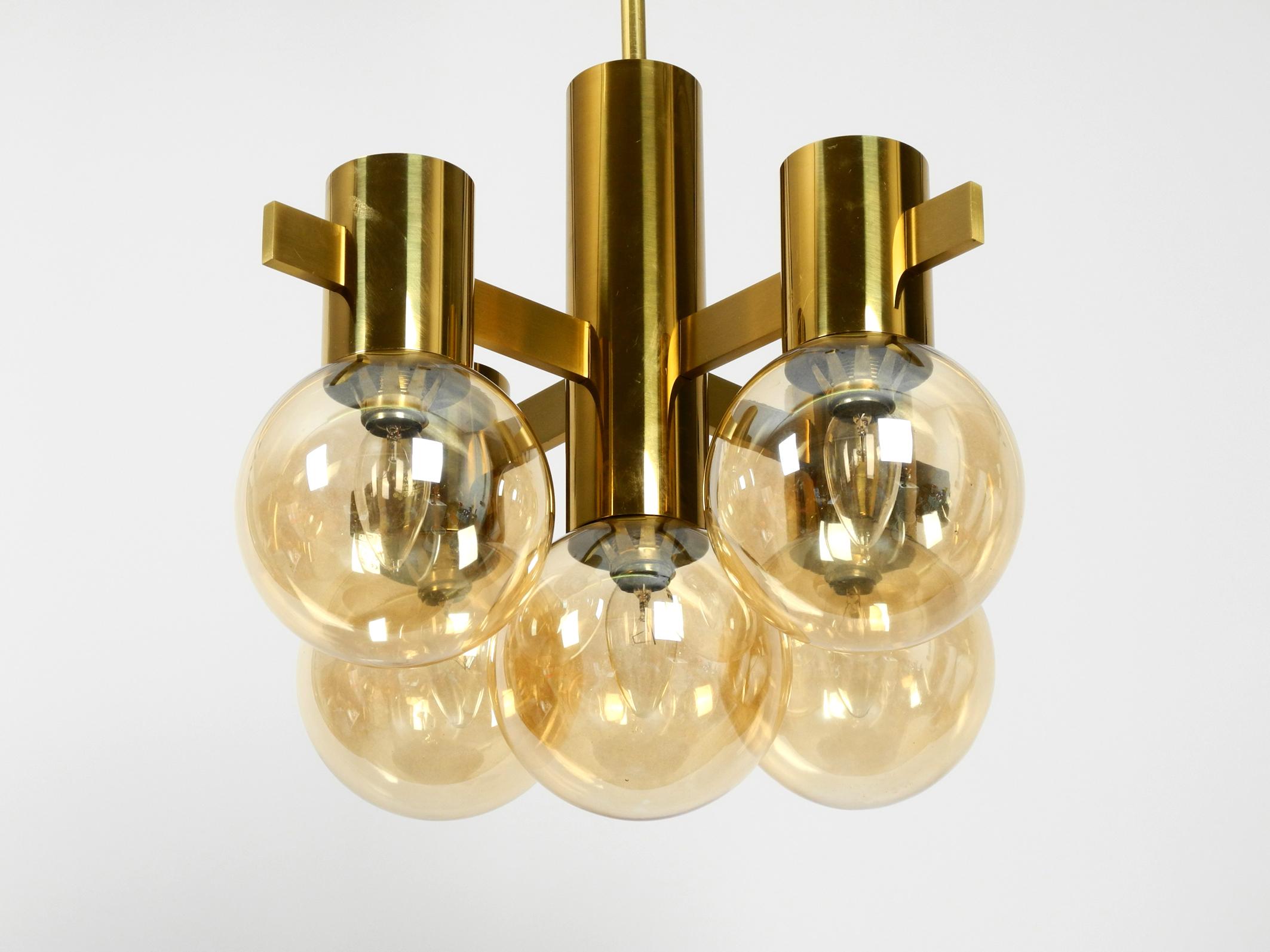 Beautiful rare brass ceiling lamp from the 1960s with 5 glass balls by 
Hans Agne Jakobsson. Made in Sweden. 
Large glass balls tinted golden. 
Entire lamp, canopy and rod are made of polished brass. 
Gorgeous elegant design. Very high quality.