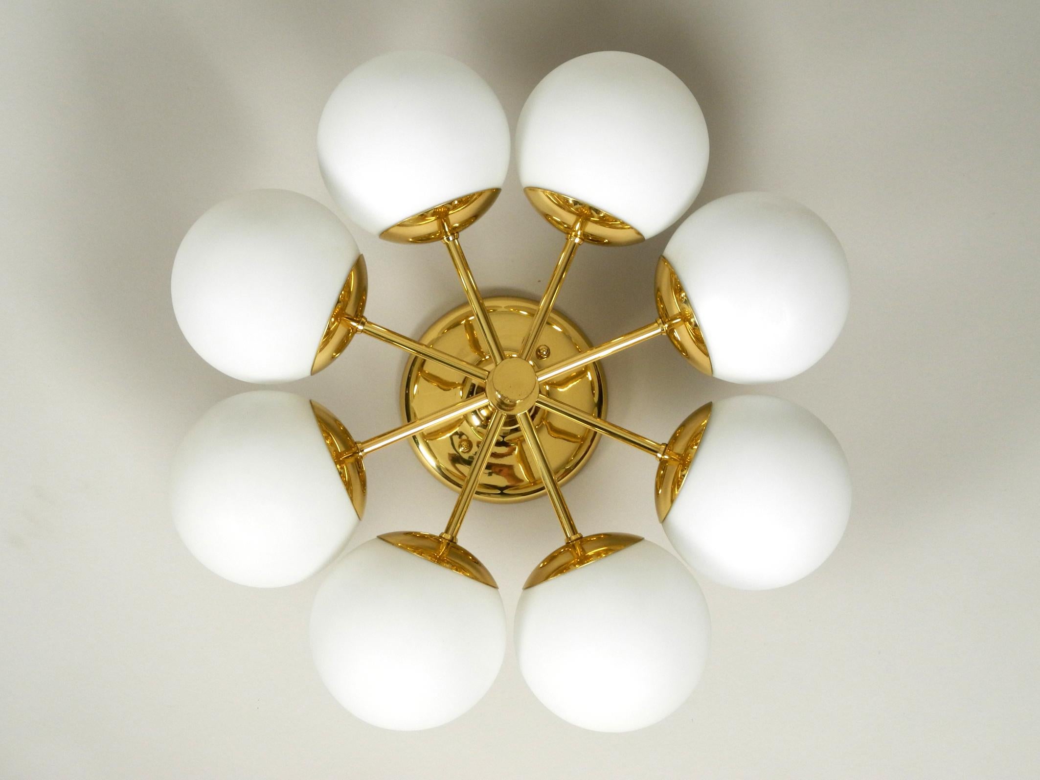 Beautiful 1960s brass ceiling lamp with 8 white opal glass balls.
The manufacturer is Kaiser Leuchten. Made in Germany.
Great 1960s space age atomic design.
Very good vintage condition. Hardly visible signs of use.
The high-glossy brass frame is