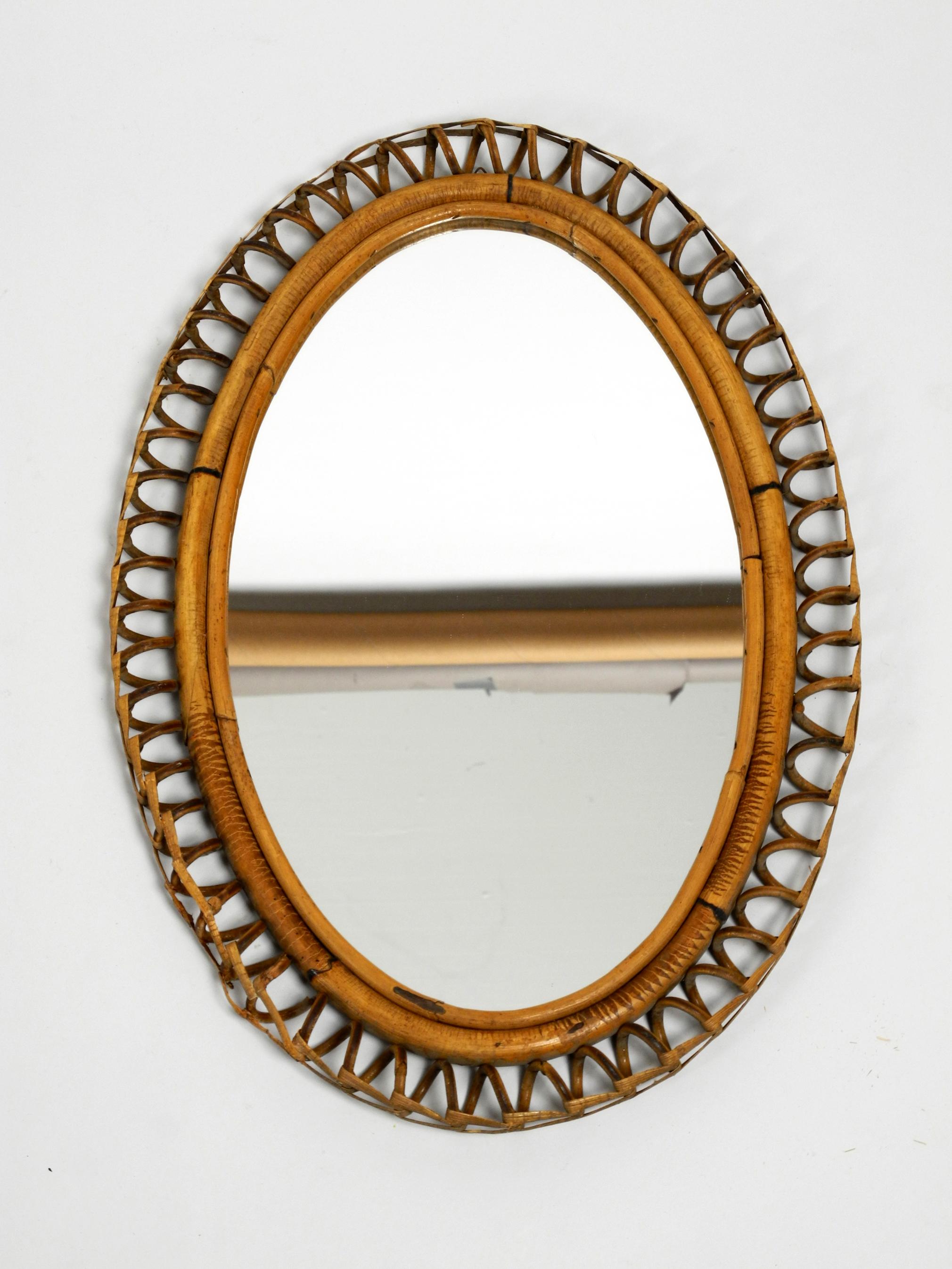 Beautiful rare Italian bamboo wall mirror from the early 1960s. 
Frame and loops are made of curved brown bamboo. 
Abstract minimalistic design. Made in Italy.
Mirror without damages. Not dull.
A couple of very light scratches on the mirror