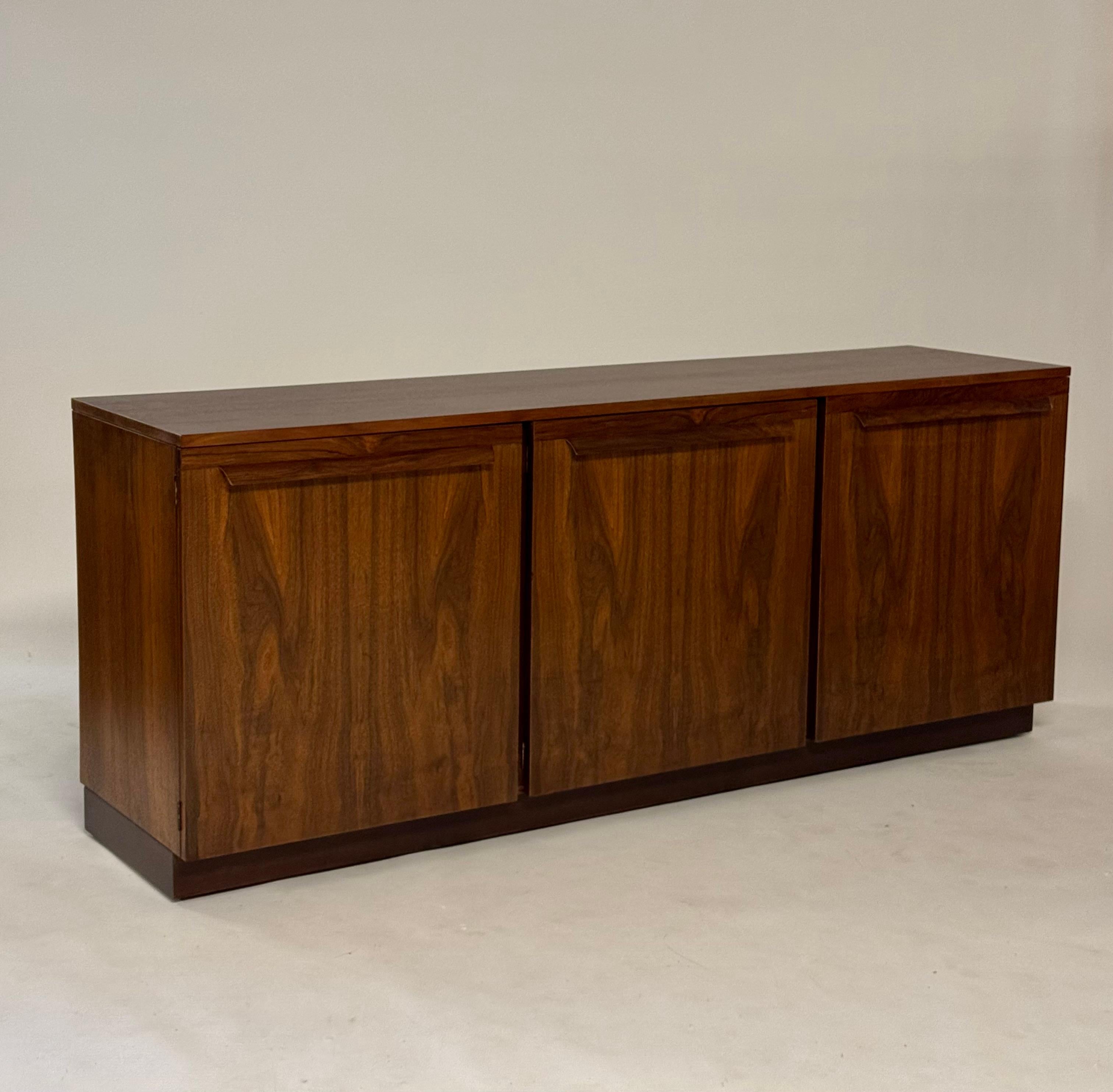 Magnifique buffet minimaliste du milieu du siècle dernier en bois de rose à trois portes par Directional, vers les années 1960, entièrement remis à neuf. Incroyables portes d'armoire en placage de bois de rose assorties aux livres, avec poignées