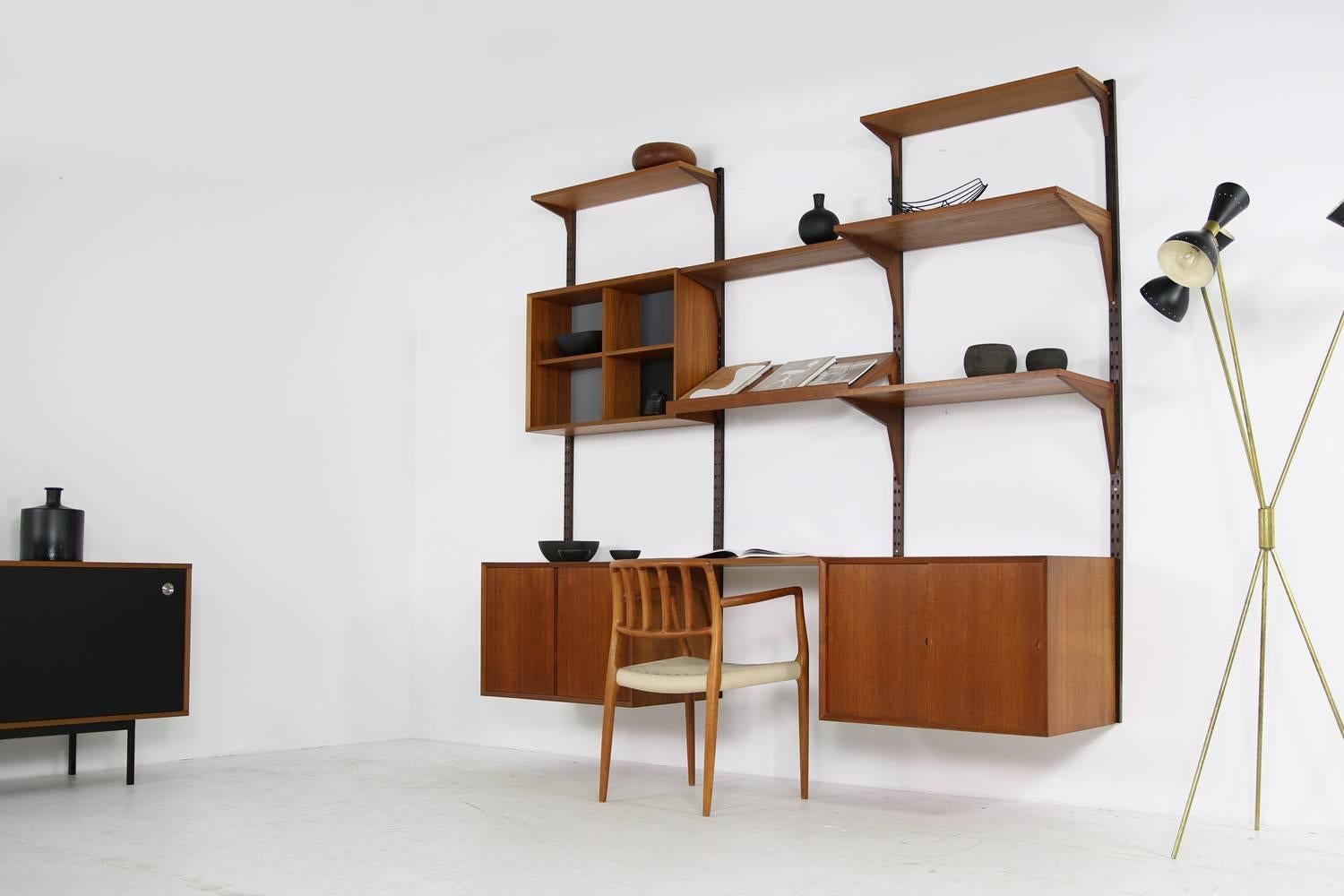 Fantastic 1960s teak wall unit designed by Poul Cadovius made by Cado, Denmark. The Scandinavian Royal shelving system is in a good condition, great patina on all parts, several teak color tones become one. Fully modular system.
Measures like built