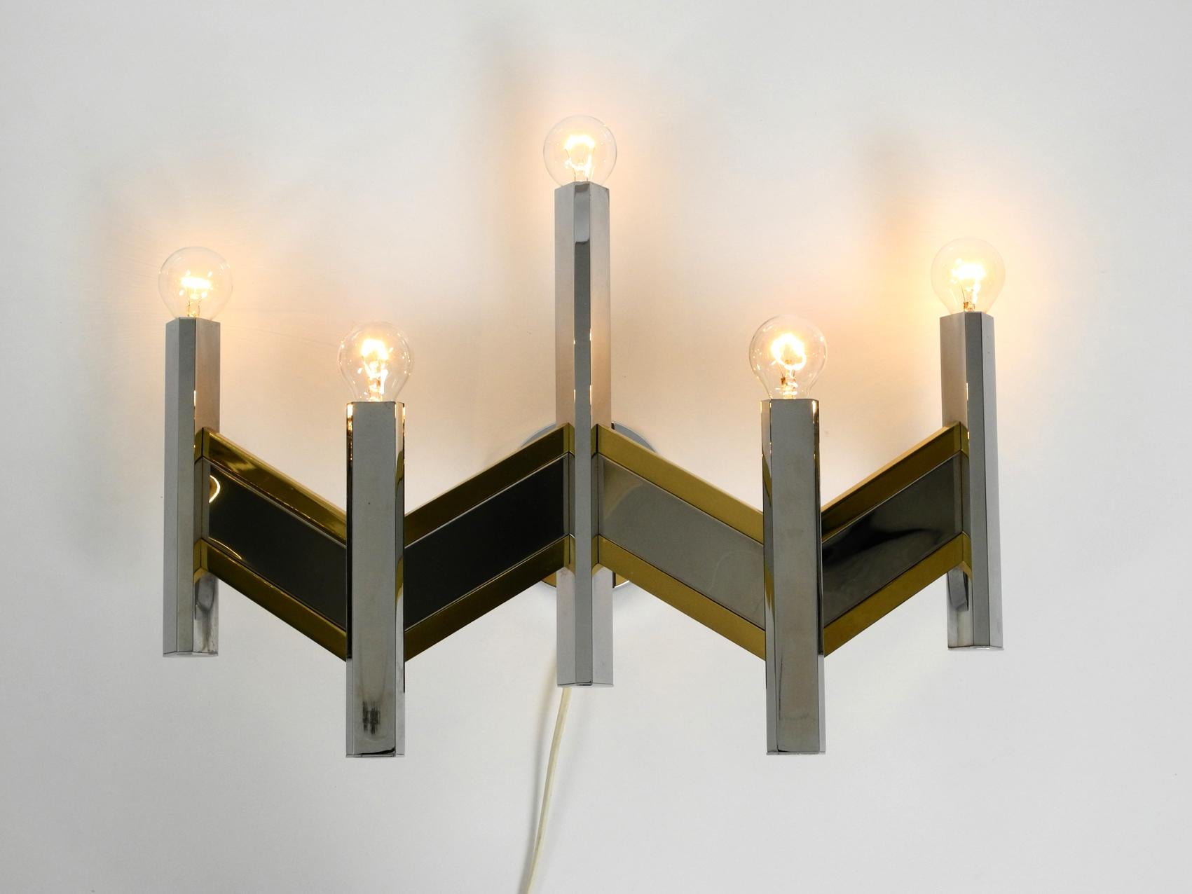 Beautiful 1970s 5-armed wall lamp by Gaetano Sciolari. Model 19009. Made in Italy. 
With original label. High glossy polished chrome and brass.
High quality minimalistic Sciolari design with many details. 
Very good vintage condition without