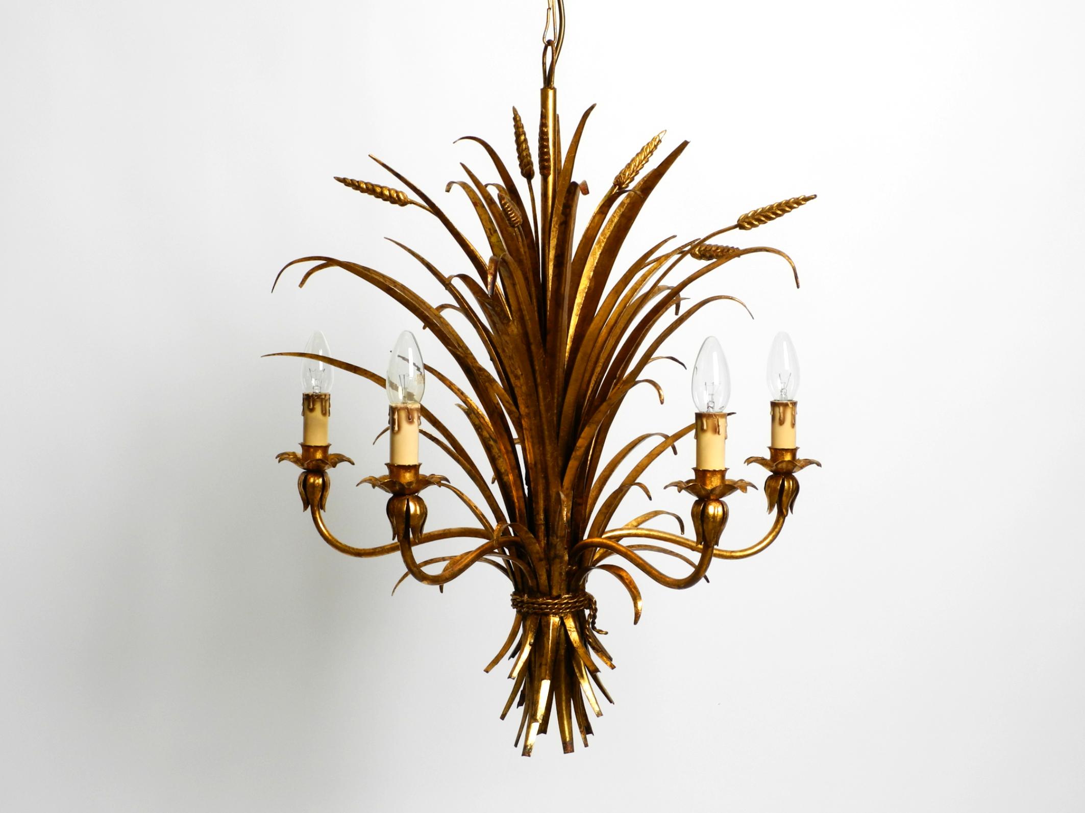 Beautiful 1970s gold-plated 5-arm tall metal chandelier by Hans Kögl.
Hans Kögl was a famous lighting and table designer. He worked with natural shapes such as palm leaves and other plant shapes. His designs were produced in both Germany and