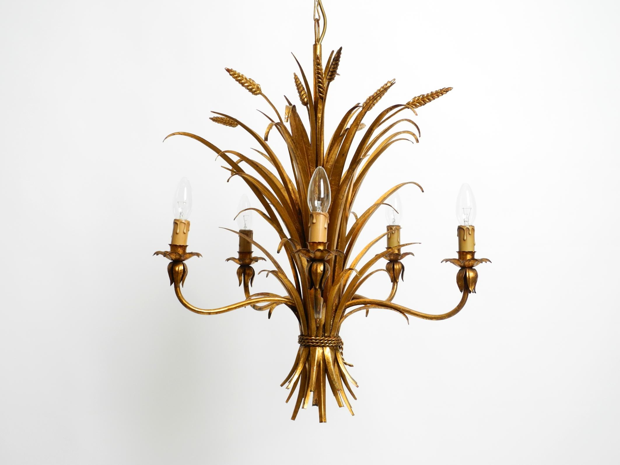 Bellissimo lampadario a 5 bracci in metallo placcato oro degli anni '70 di Hans Kögl.
Hans Kögl era un famoso designer di illuminazione e di tavoli. An He lavorava con forme naturali come le foglie di palma e altre forme vegetali. I suoi disegni