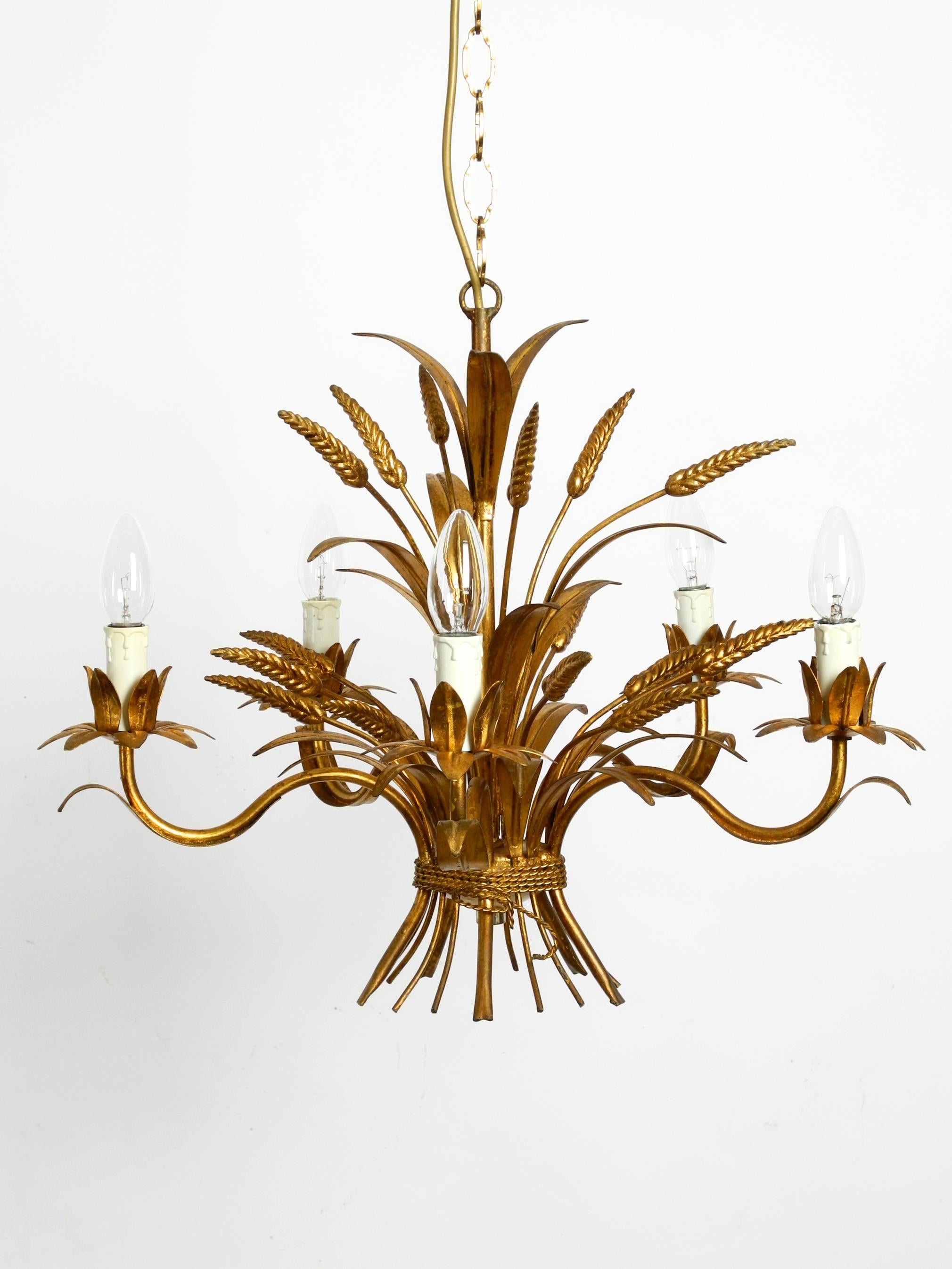 Beautiful 1970s gold-plated 5-armed metal chandelier by Hans Kögl. 
Hans Kögl was a famous light and table designer. 
He worked with natural shapes like palm leaves and other plant shapes. 
His designs were produced in both Germany and Italy.