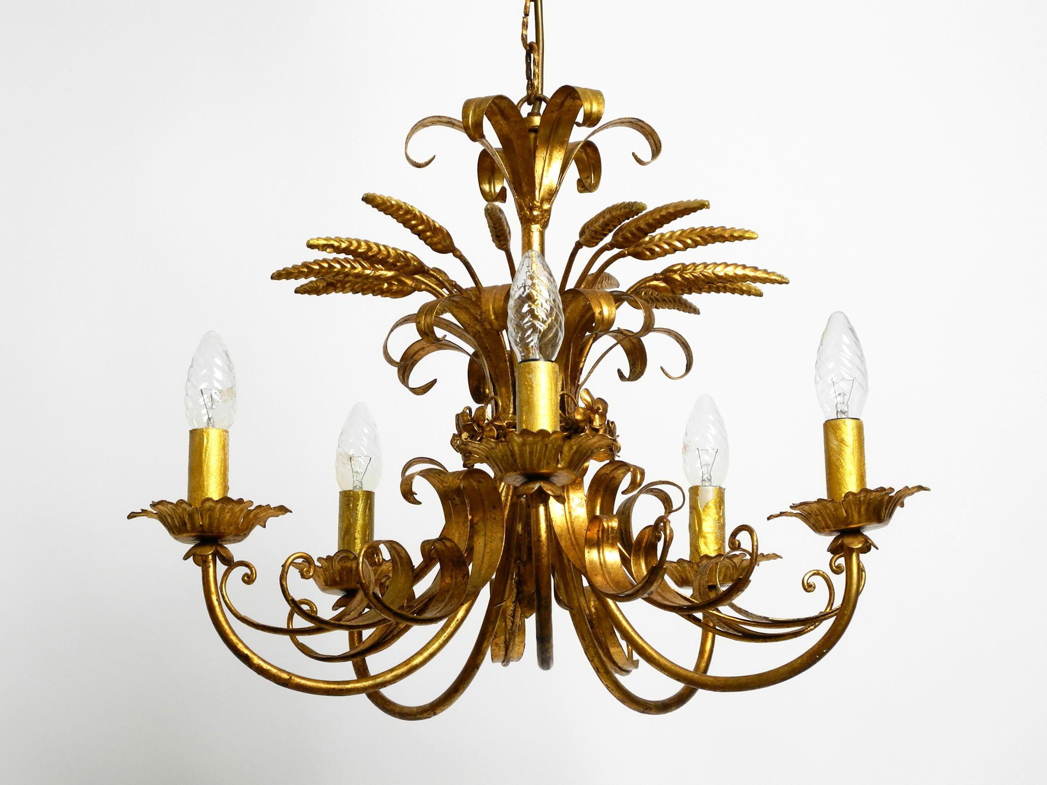 Beautiful 1970s large gold-plated 5-arm metal chandelier by Hans Kögl. In the shape of a wheat sheaf.
Great and very high quality workmanship with lots of details.
Hans Kögl was a famous lighting and table designer. He worked with natural shapes