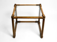 Beautiful 1970s side table made of dark bamboo wood with a glass top