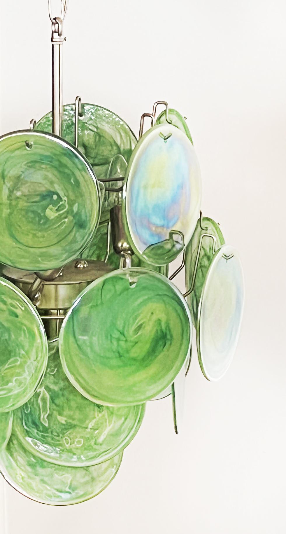 Vintage Italian Murano chandeliers in Vistosi style. The chandelier has 24 fantastic iridescent alabaster green discs in a nickel metal frame.
Period: late XX century
Dimensions:41,30 inches (105 cm) height with chain; 20,50 inches (52 cm) height