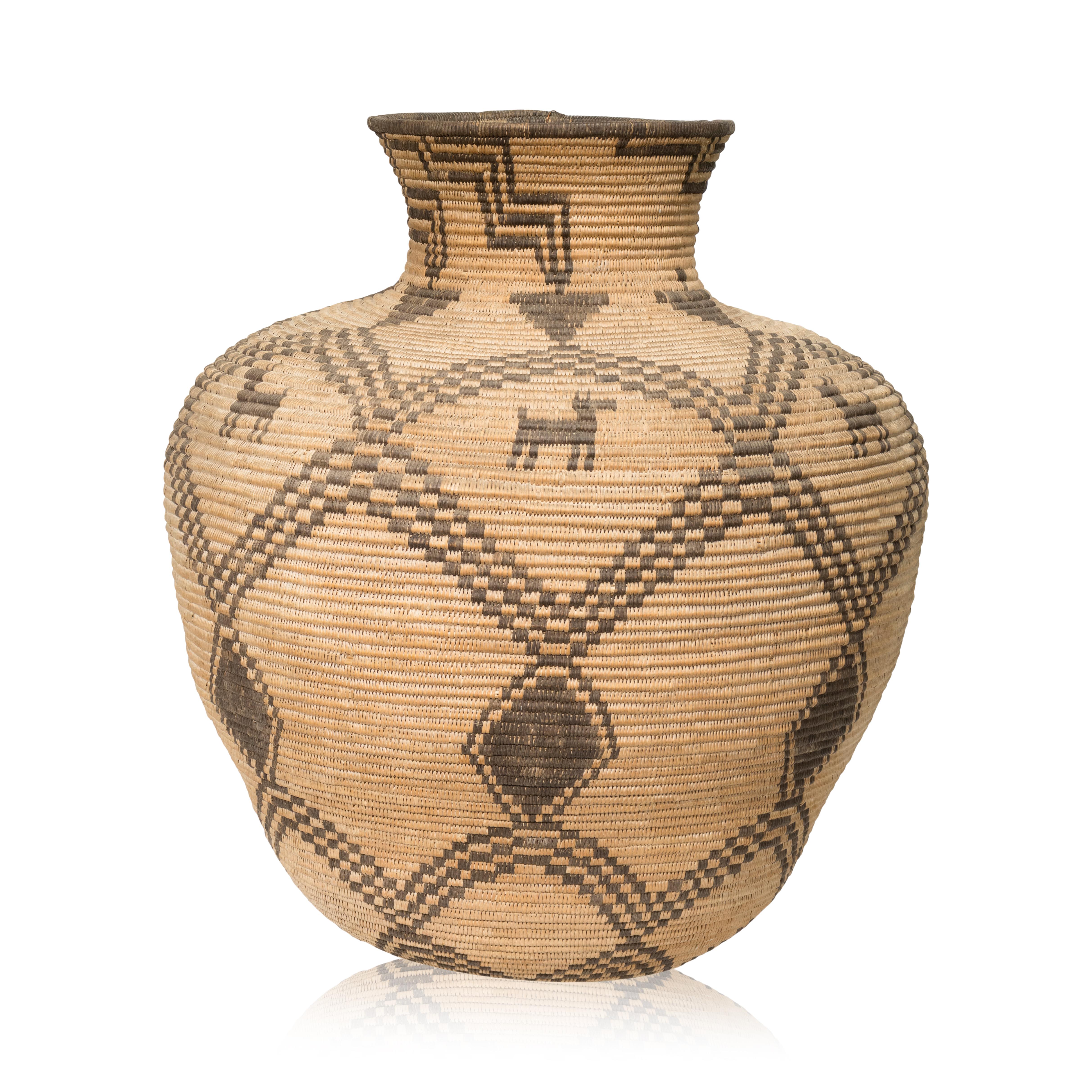 Apache figural basketry olla with seven dogs on shoulder. After an olla was filled to the brim with wild grass seeds such as chia or amaranth, or domestic plant products like corn or beans, a basketry lid or cover was put on top to protect the food