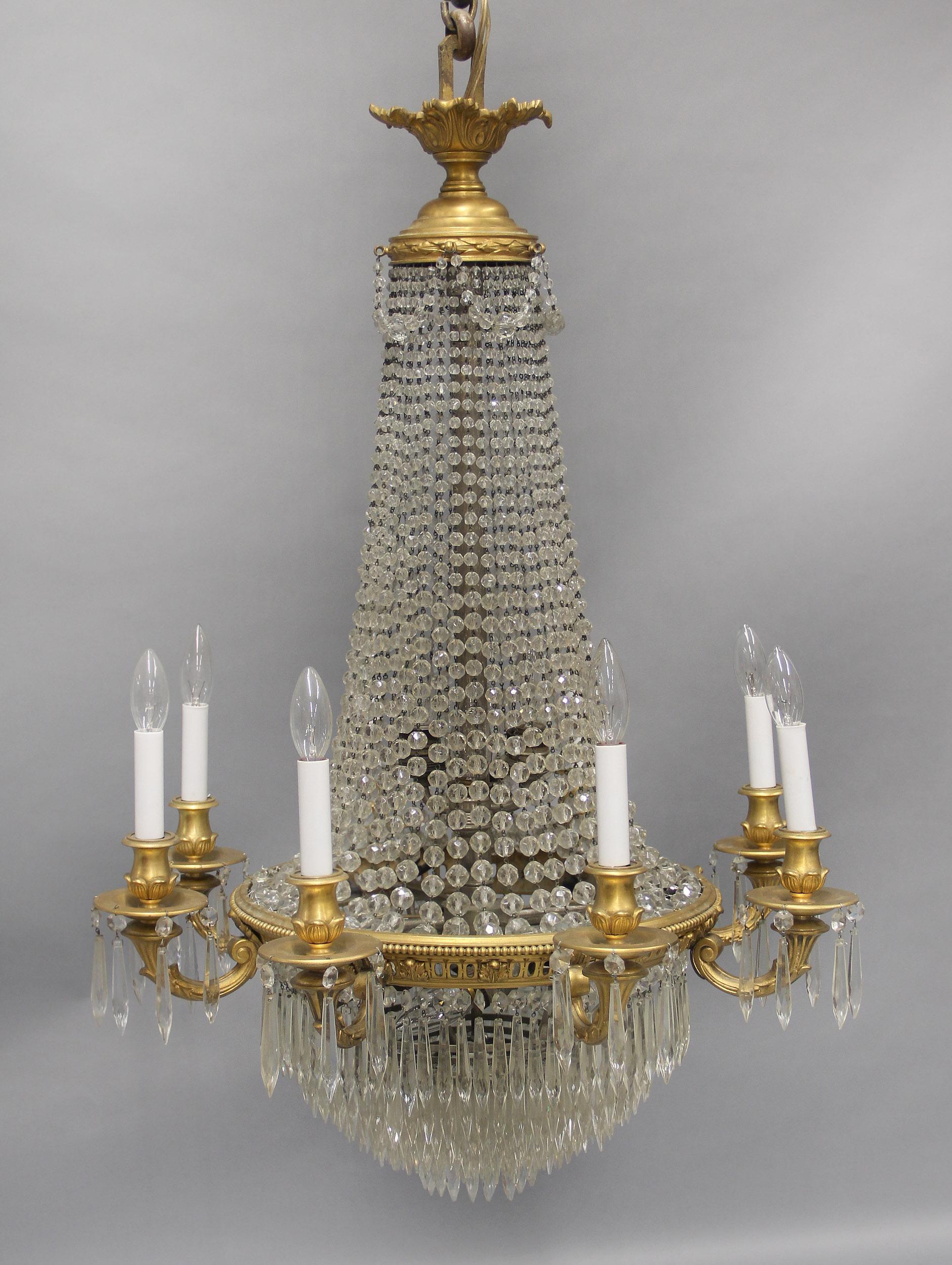 A Beautiful Late 19th Century Gilt Bronze and Beaded Seventeen Light Drop Crystal Chandelier

Crystal swags along the crown with flowing beads leading down to a designed bronze rim with eight arms and finishing with a layered drop crystal base
