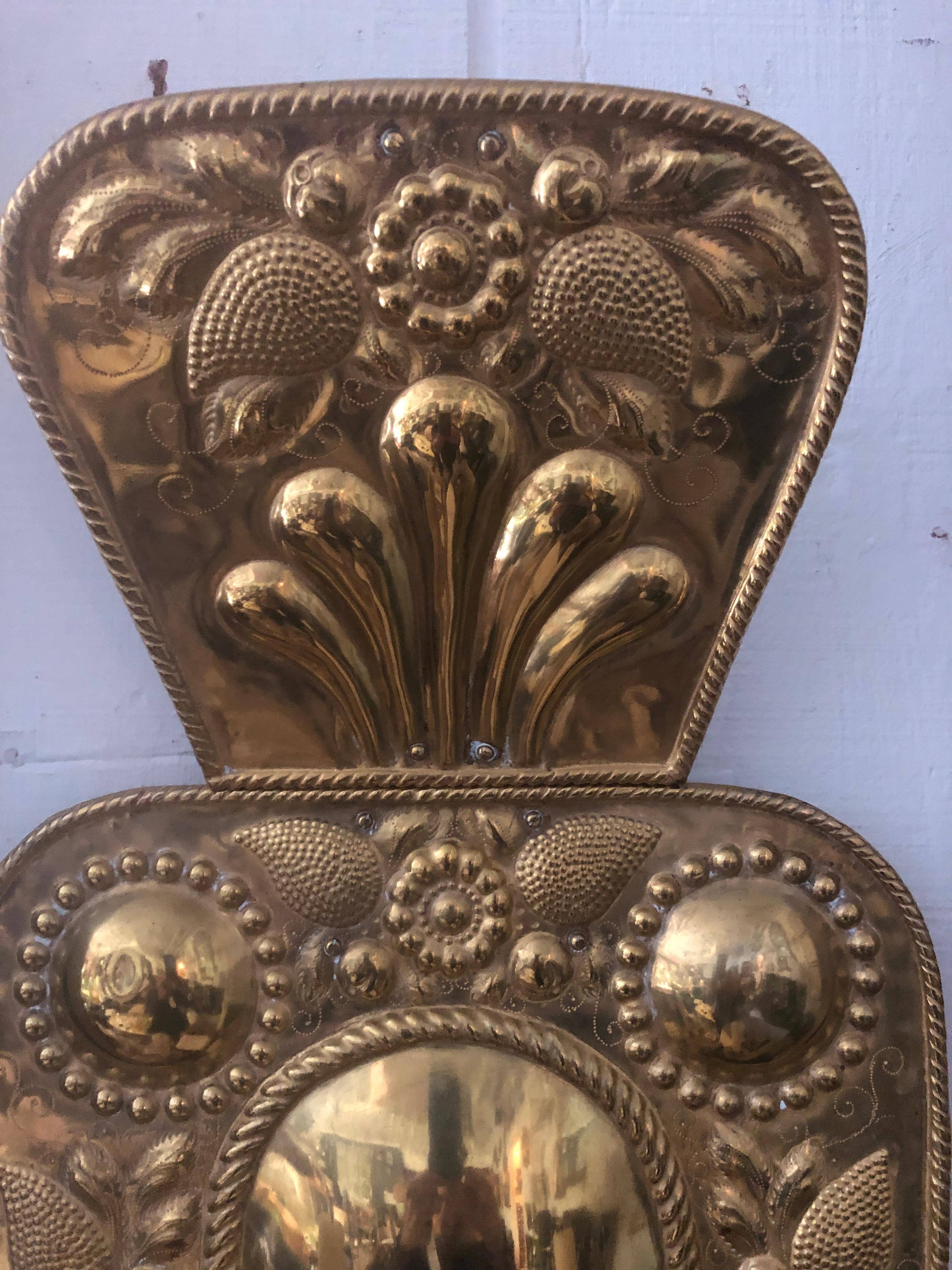 Beautiful antique Dutch brass candle sconce having two arms and wonderful raised decoration.