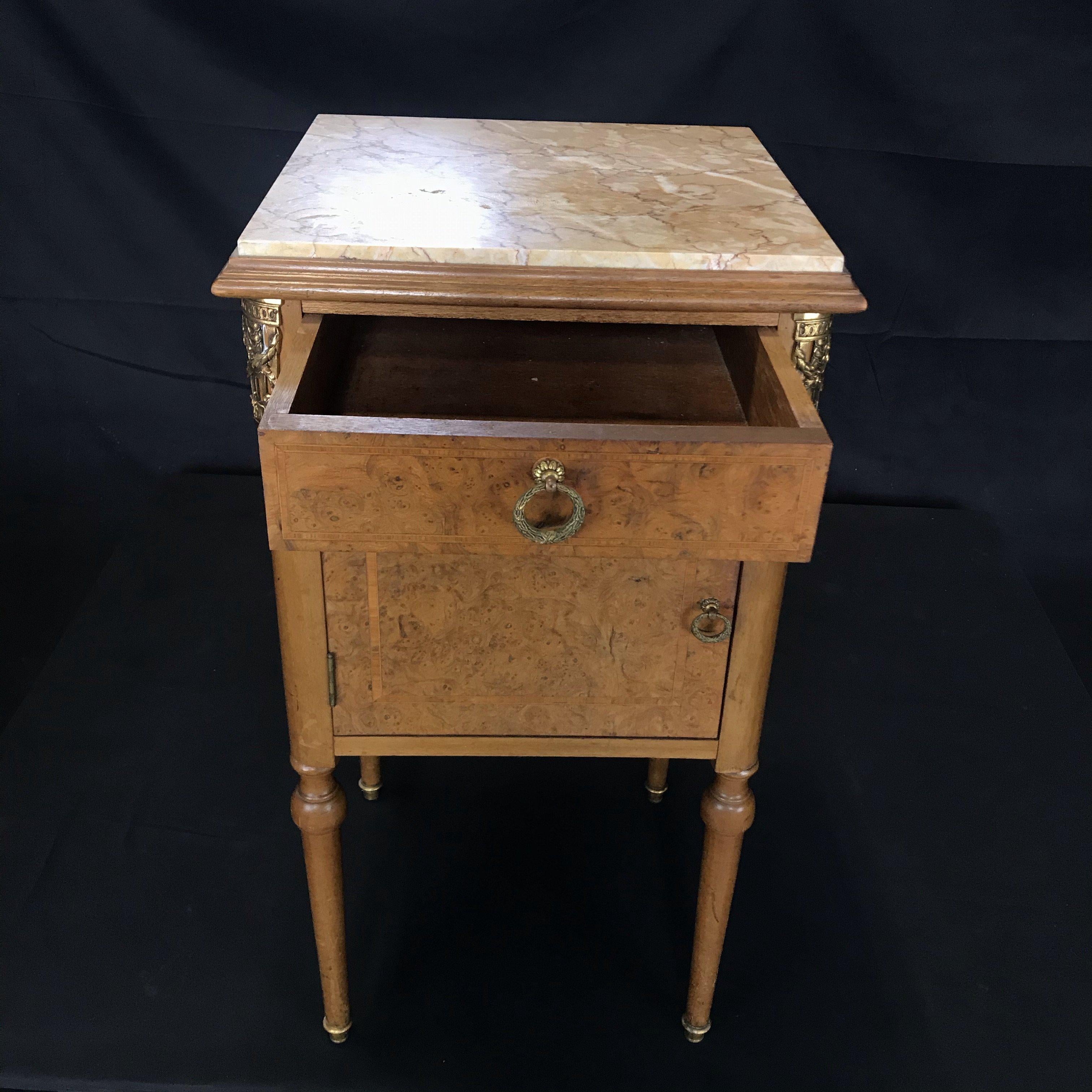 Much versatility in this beautiful inlaid French marble top night stand, bedside table or side table. Lovely inlay on the front under a beige ivory marble top, with one dovetailed drawer and an open cabinet below. Perfect in a bedroom, bathroom or
