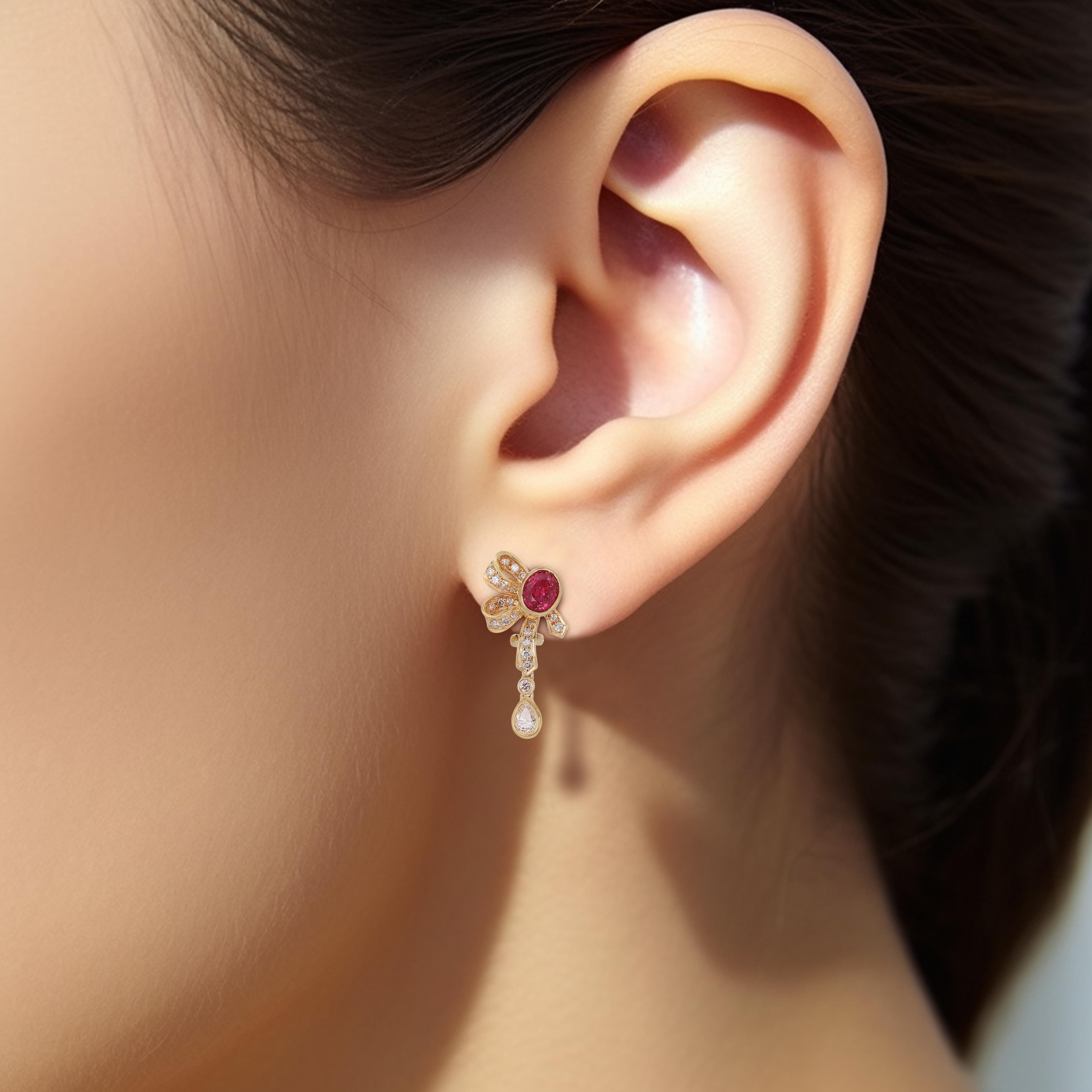 Ces exquises boucles d'oreilles pendantes en or jaune 18 carats comportent deux rubis de forme ovale de 2,02 carats, deux diamants de taille princesse de 0,68 carat, 40 diamants ronds de taille brillant de 0,2 carat, pour un poids total en carats de