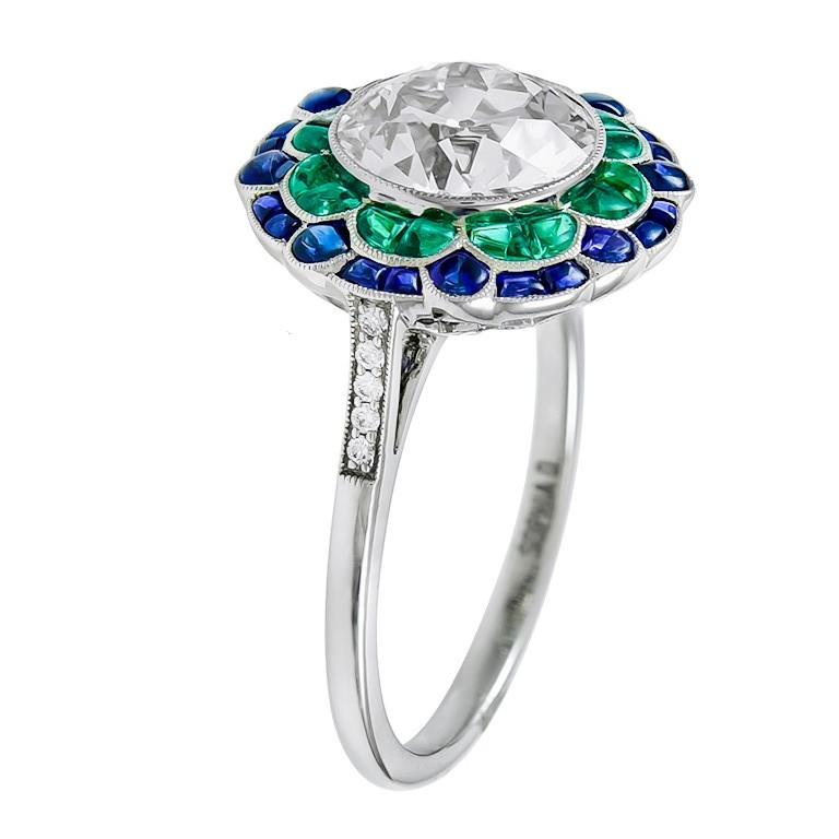 Art Deco inspired ring in platinum setting with blue sapphires weighing 1.20 carats, emeralds weighing 0.90 carats, diamonds weighing 0.04 carats and center round diamond weighing 2.16 carats. 

Sophia D by Joseph Dardashti LTD has been known