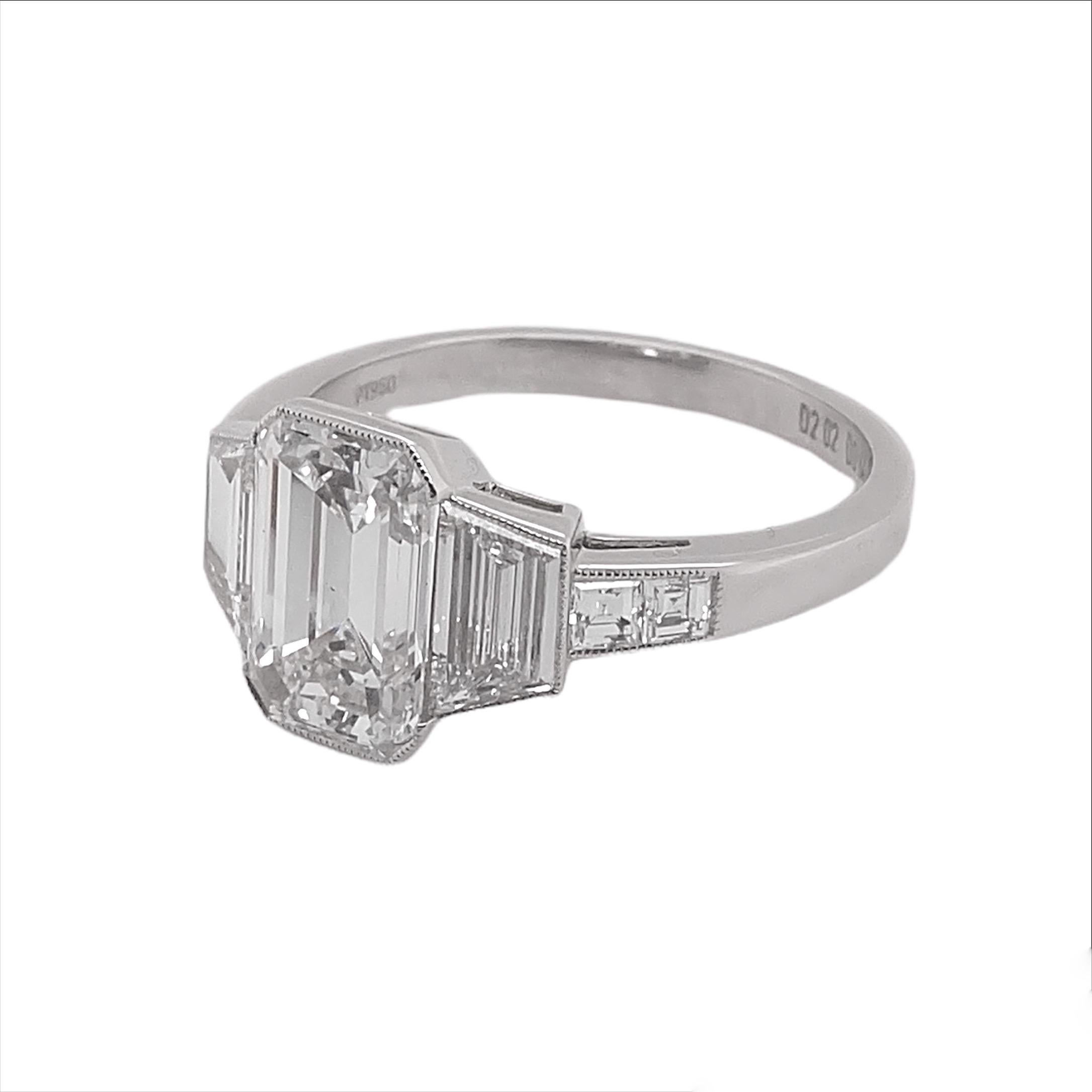 This beautiful Platinum Diamond Ring is centered with a GIA certified emerald cut diamond that weighs 2.22 carat with a color and clarity of E-VS2. Accentuating the center stone are trapezoid cut diamonds that weigh 0.64 carat with small diamonds