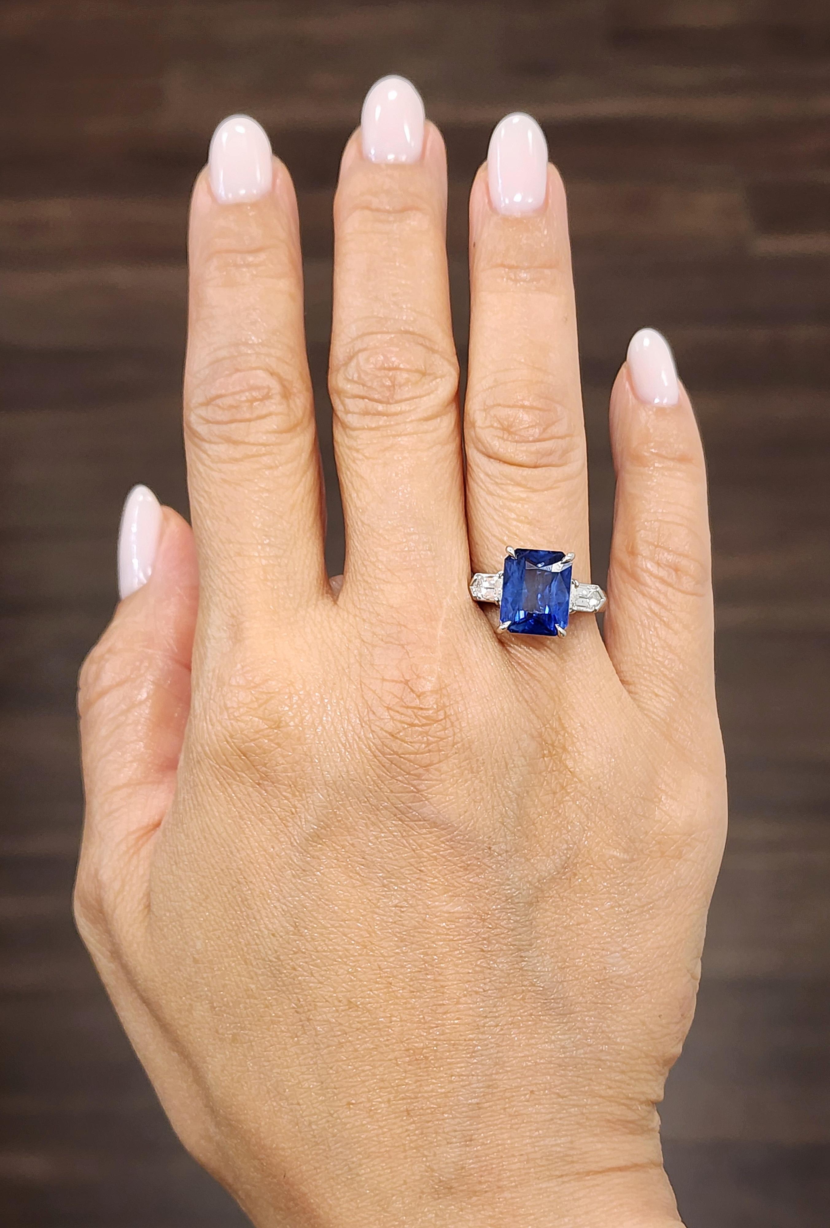Cette magnifique bague en saphir naturel et diamant est une pièce d'apparat intemporelle. La bague est ornée d'un saphir naturel certifié GIA d'un poids de 5,40 carats en guise de pierre centrale. Le saphir est flanqué de deux diamants en forme