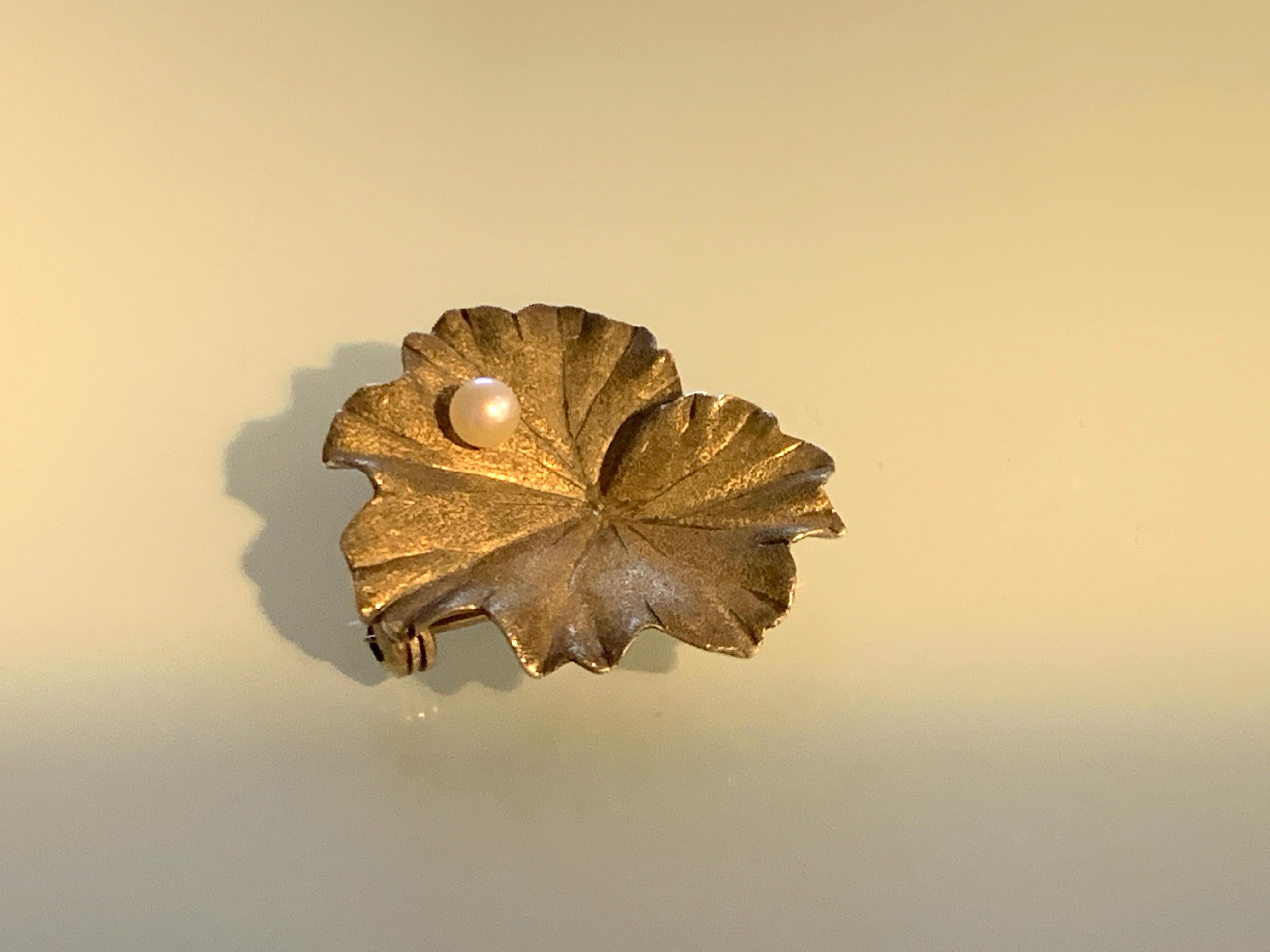Beautiful rare Waterlily
9ct Gold brooch
with a cultured pearl balanced on its surface
Has a beautiful sand blasted surface which has a darker appeal -
fully hallmarked on reverse
London import mark 9 375 and date letter 
