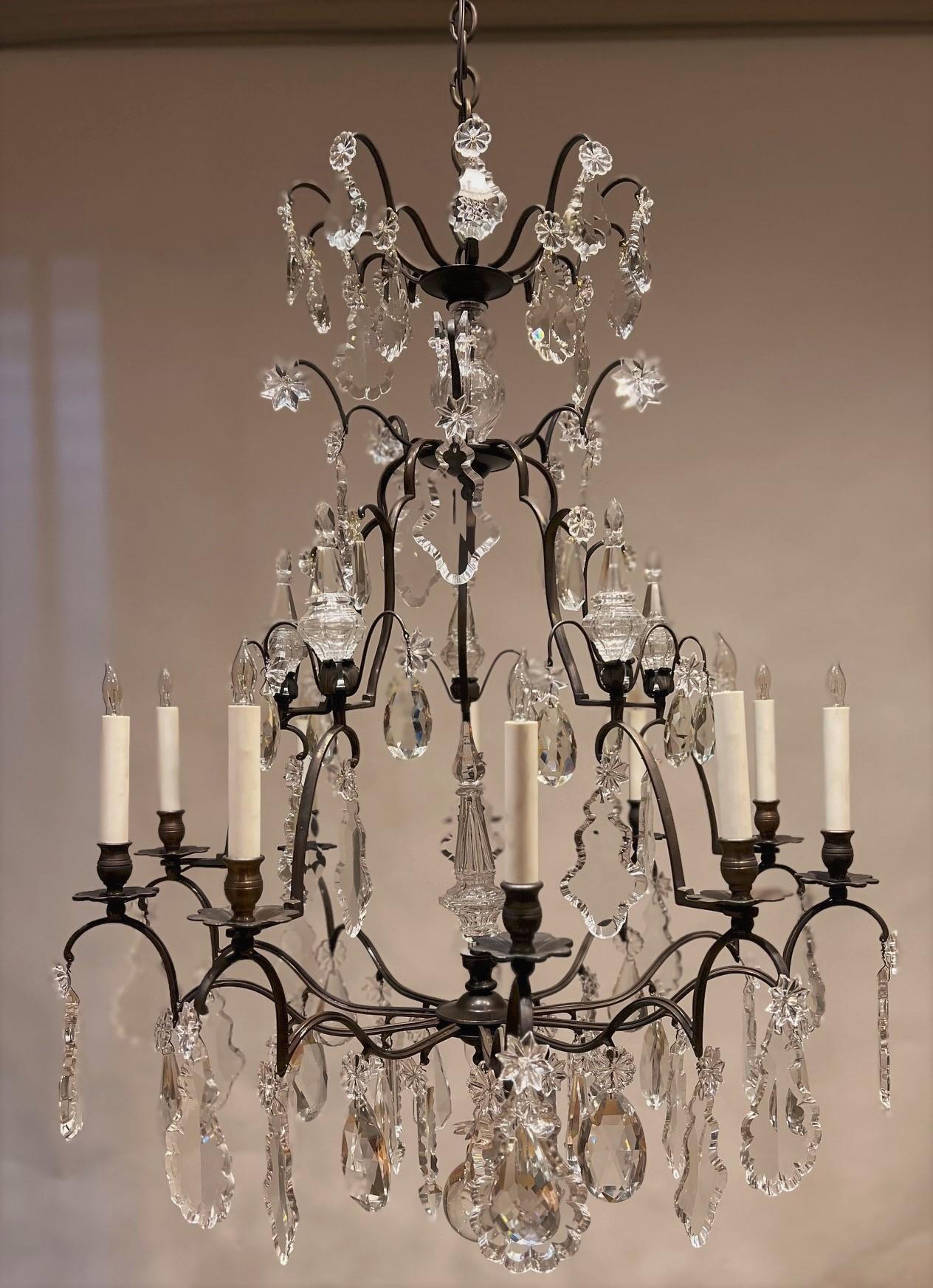 The amazing thing about this fixture is that, in spite of its size and the number of lights, its open design gives it a minimalist look. This Louis XV style ten-light chandelier, circa 1920 -- France, has a very graceful open hand-wrought bronze