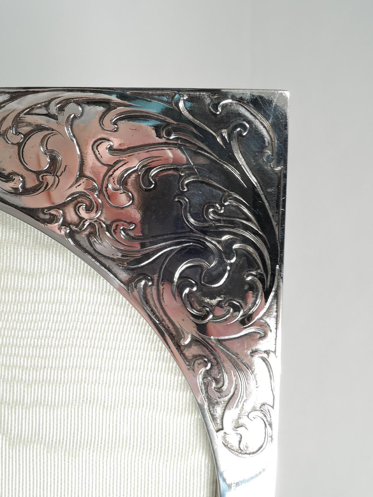 Beautiful turn-of-the-century Art Nouveau sterling silver frame. Made by Mauser Mfg. Co. in New York. Oval window in rectangular surround. Lush and exuberant leafing scrolls acid-etched on front. Sides plain. With glass, silk lining, and velvet back