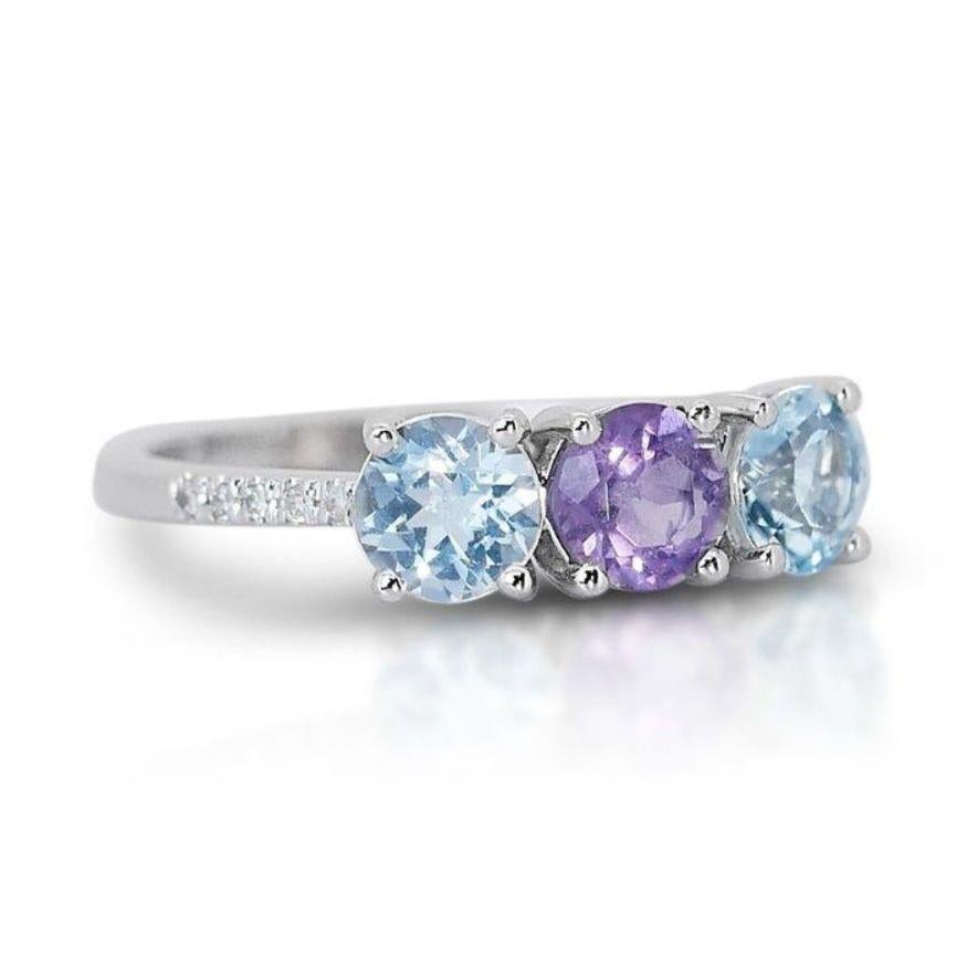 This stunning ring features a captivating 0.56 carat round brilliant amethyst, its vibrant purple unveiled by VG clarity and a masterful cut. Gleaming 18K white gold sets the stage for this royal gem, while a halo of 1.02 carat blue topaz and 0.12
