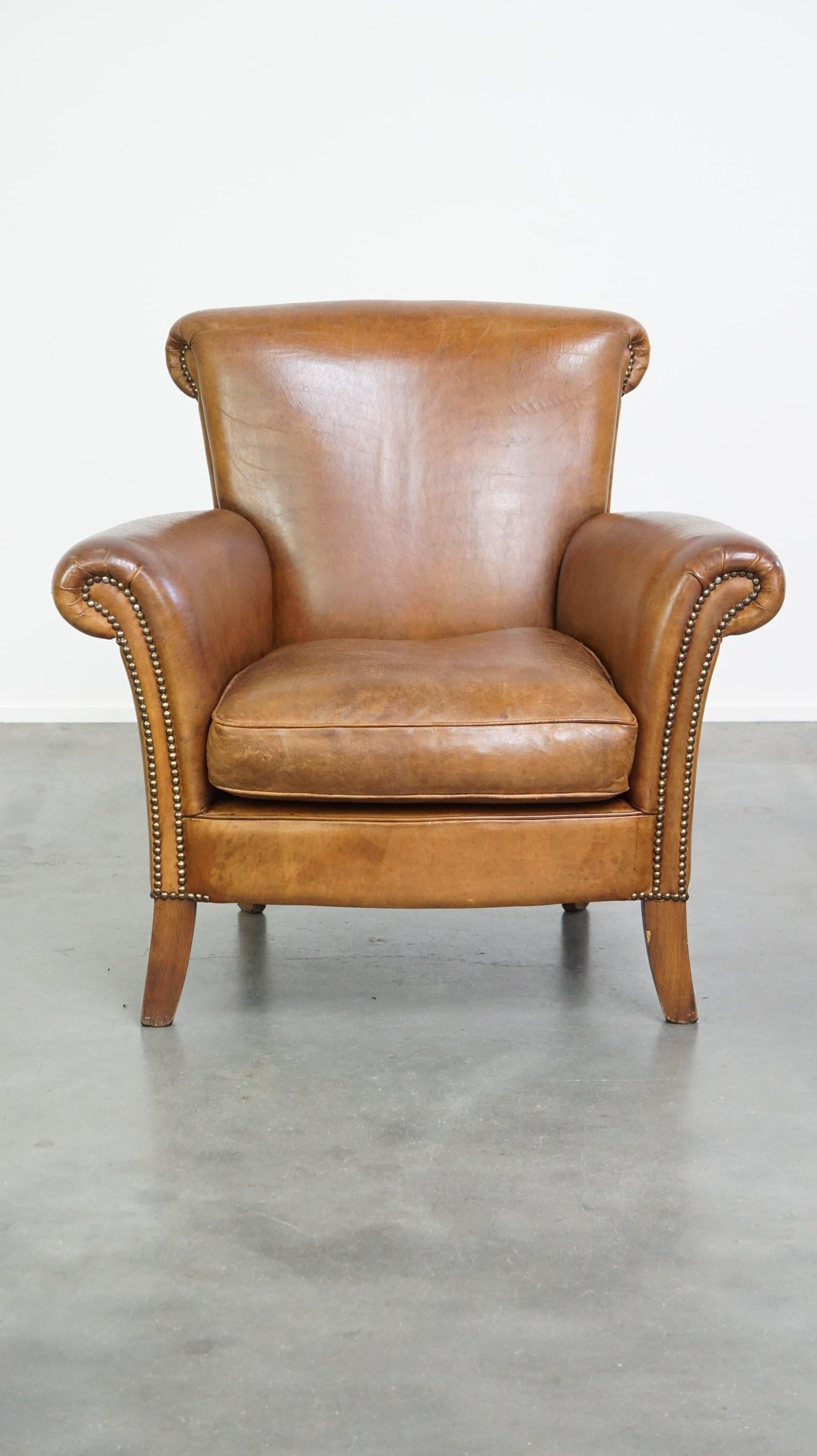 This comfortable sheepskin armchair is in good condition, showing only a few normal signs of wear. It fits perfectly into nearly any interior style and features decorative nailhead detailing along with a removable seat cushion. With proper care,