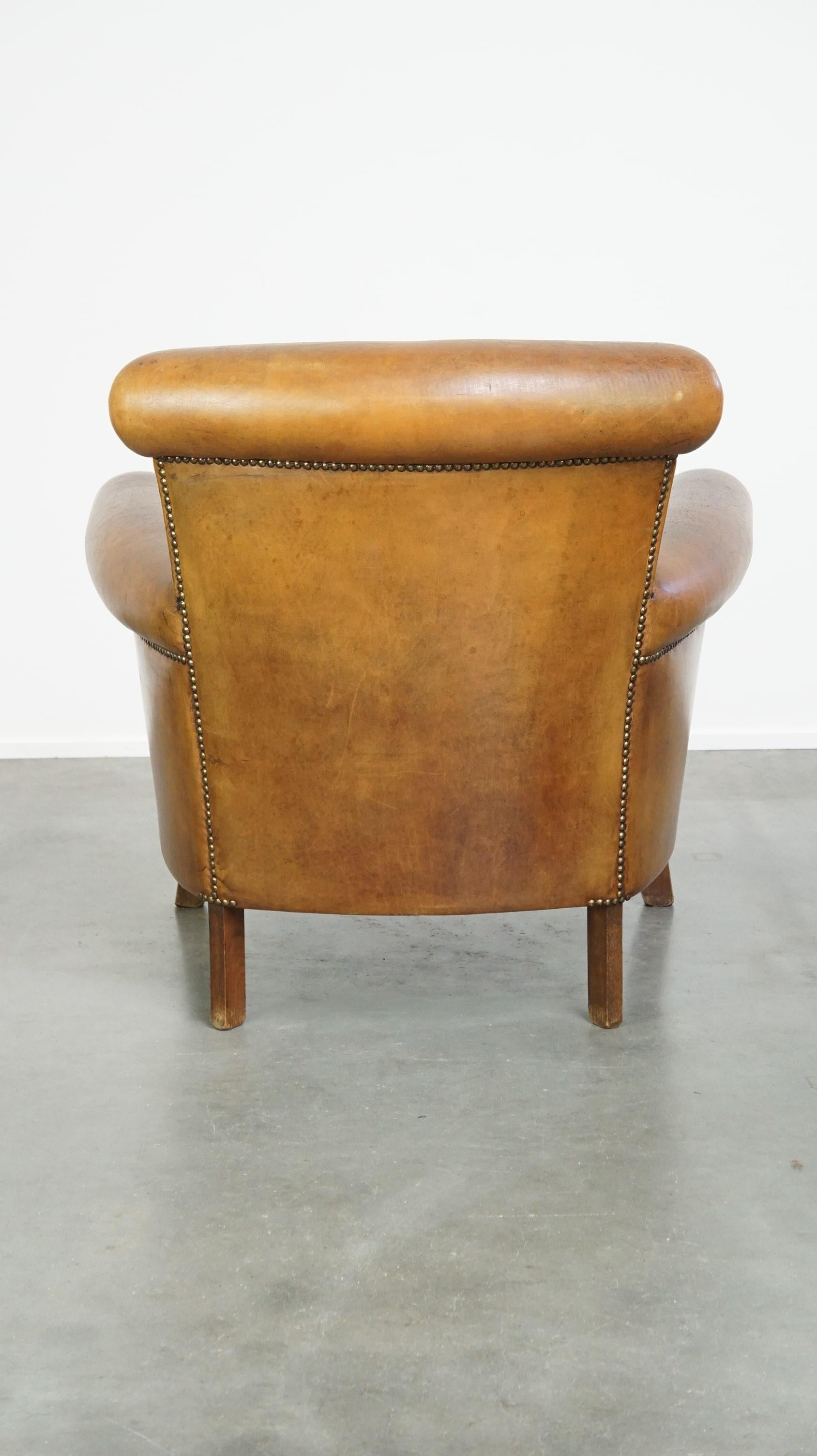 Beautiful and comfortable sheepskin armchair, finished with decorative nailheads In Good Condition For Sale In Harderwijk, NL