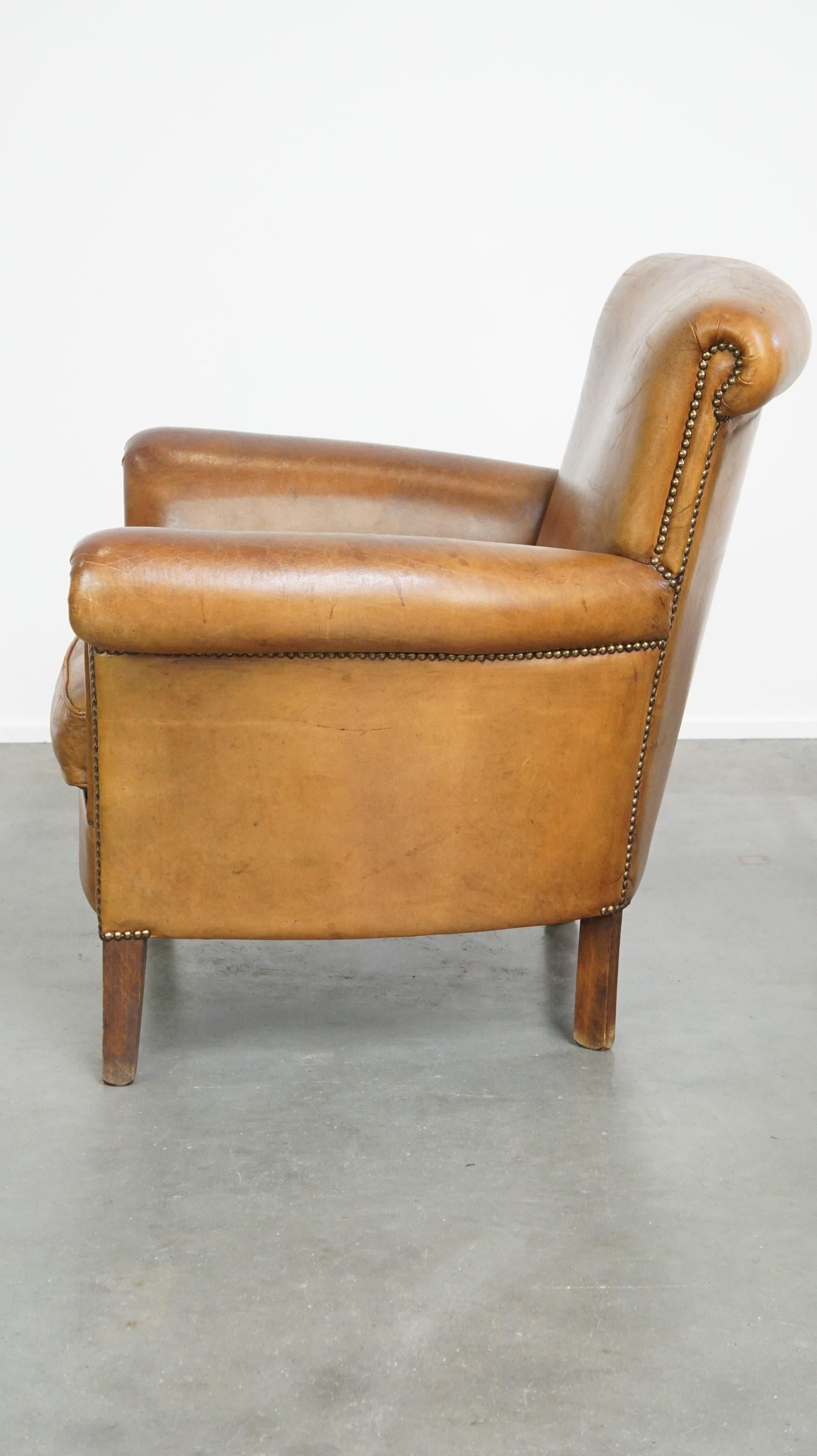 Late 20th Century Beautiful and comfortable sheepskin armchair, finished with decorative nailheads For Sale